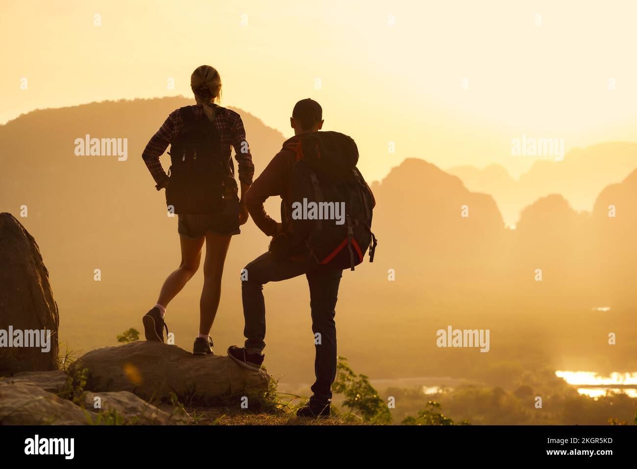 Una giovane coppia di escursionisti è in piedi al punto di osservazione dell'alba. Baia di Phang Nga, Thailandia Foto Stock