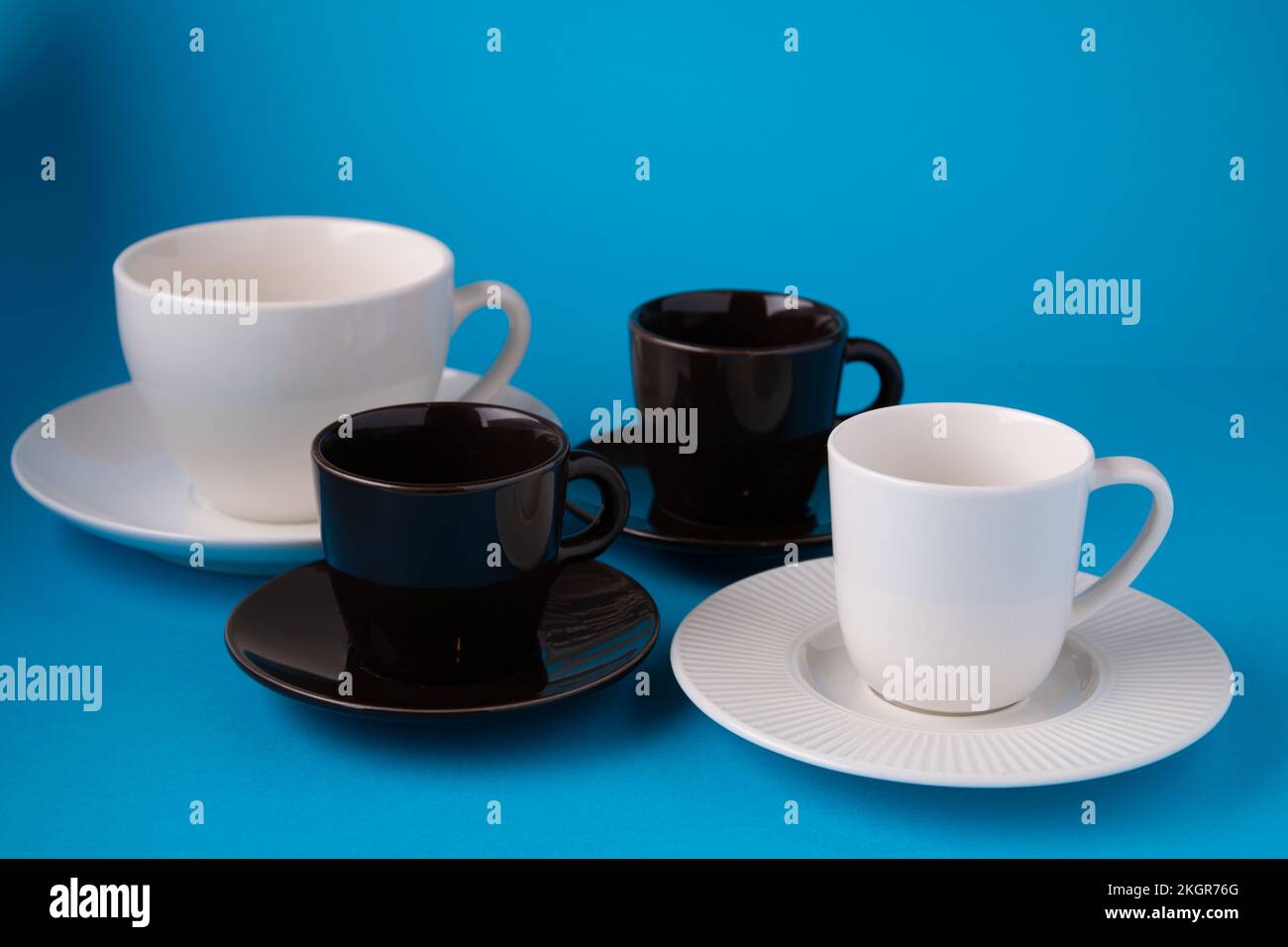 foto di tazze da caffè vuote con piattini su sfondo blu Foto Stock
