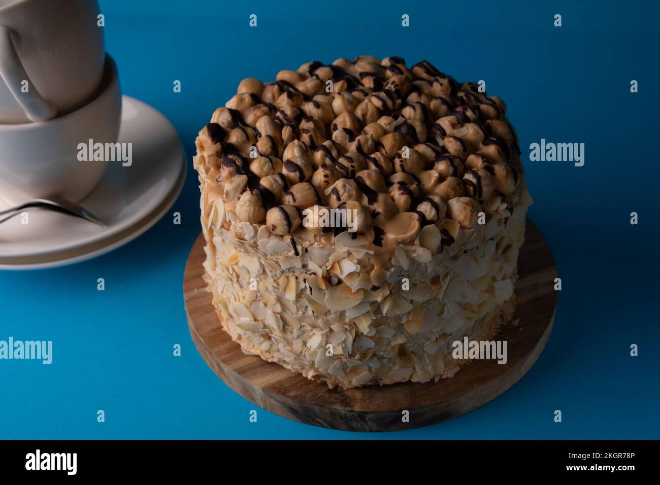 foto di una torta intera su un asse di legno su sfondo blu Foto Stock