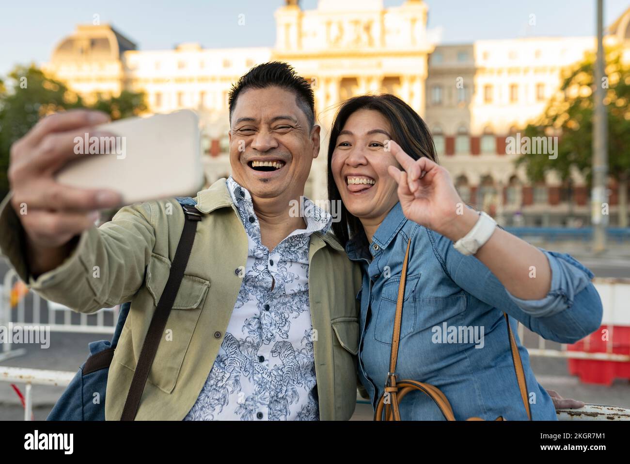 Coppia matura felice che prende selfie davanti all'edificio Foto Stock
