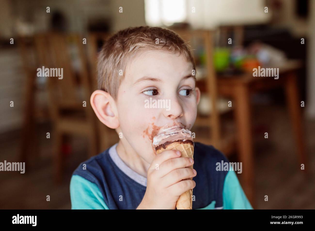 Ragazzo che mangia gelato a casa Foto Stock