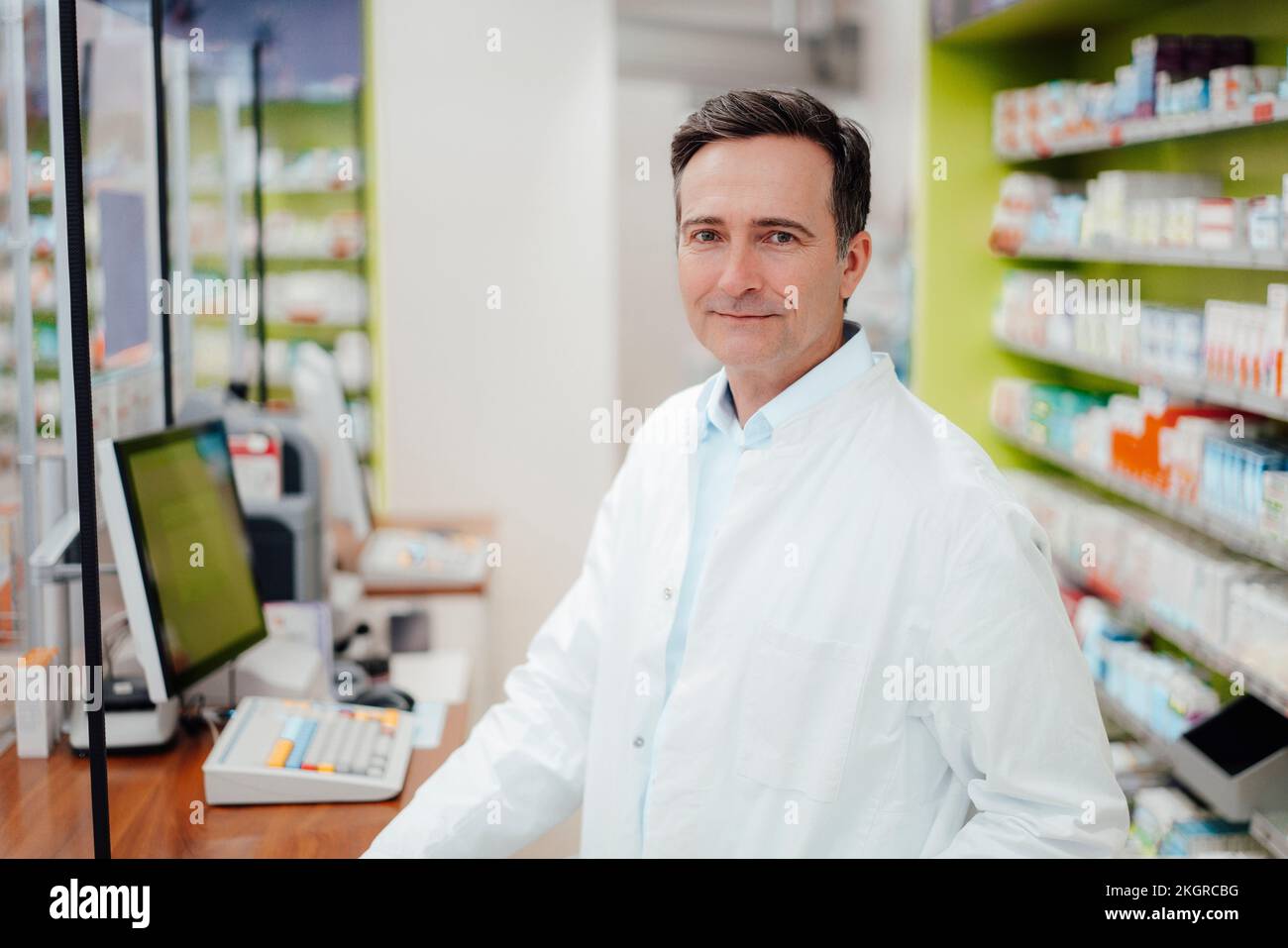 Sorridente farmacista maturo in farmacia Foto Stock