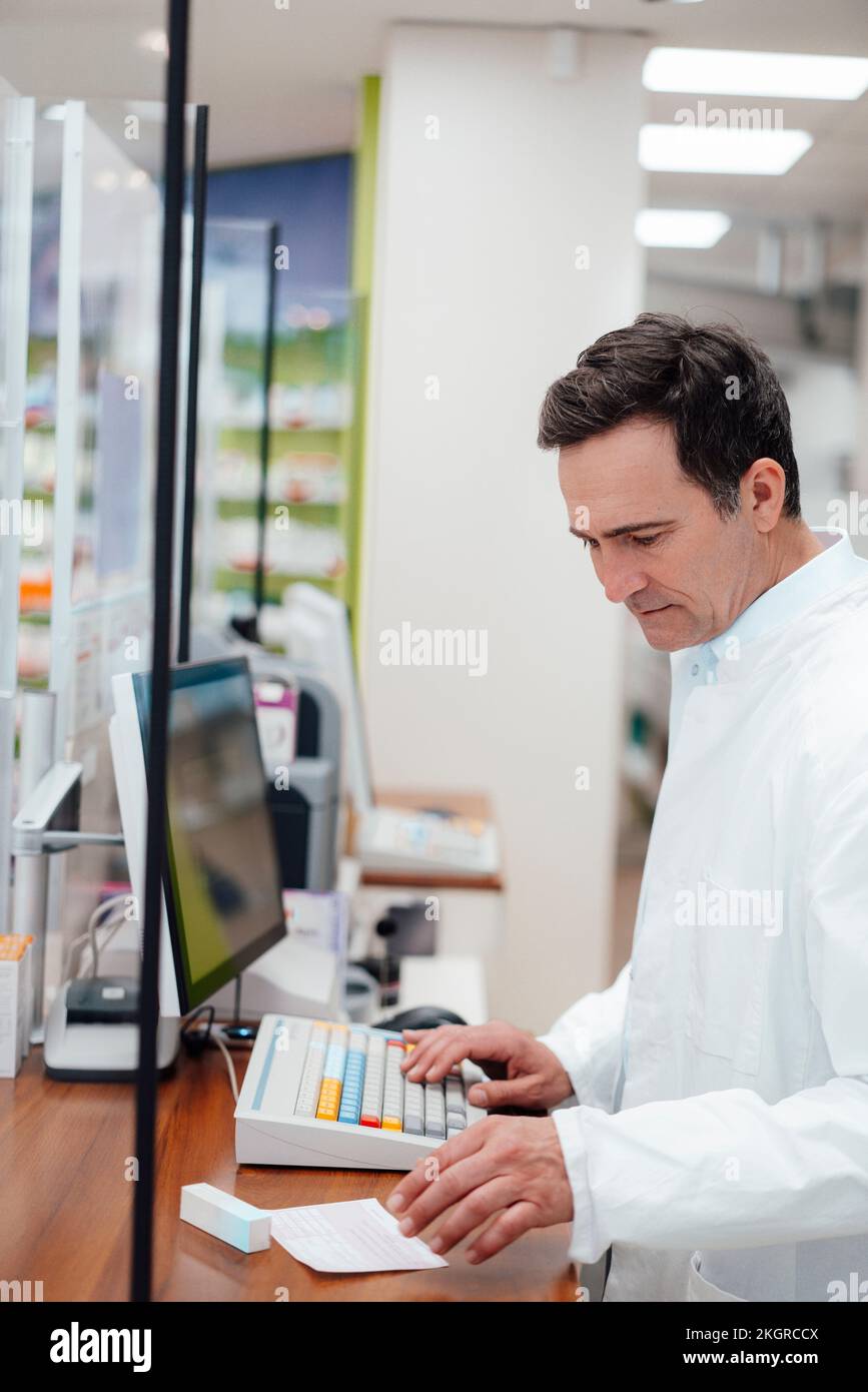 Il farmacista analizza il medicinale soggetto a prescrizione medica in magazzino Foto Stock