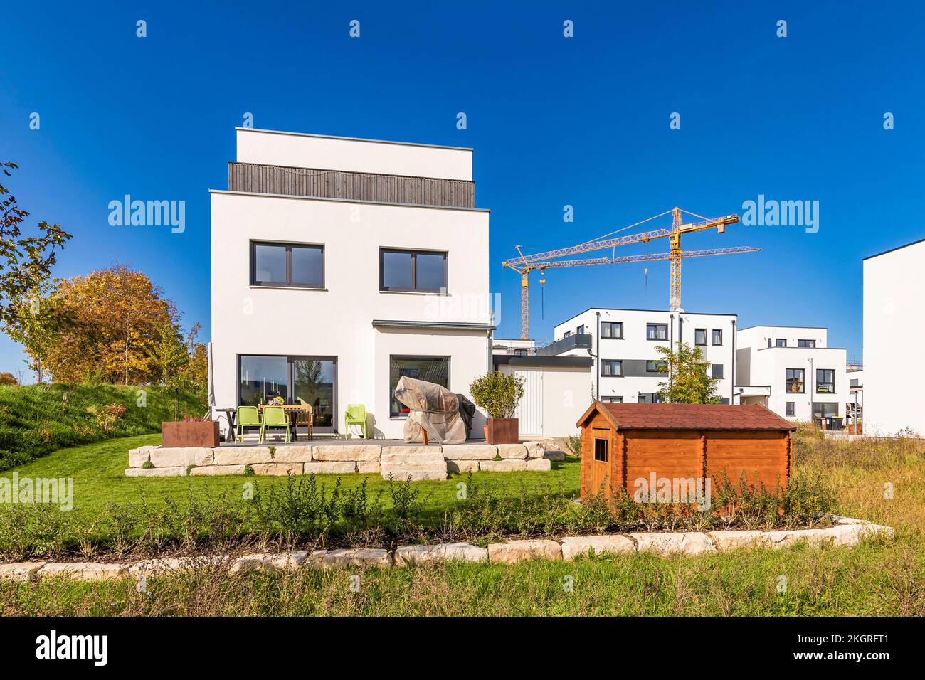 Germania, Baden-Wurttemberg, Weinstadt, cortile di moderna casa suburbana con gru industriale in background Foto Stock