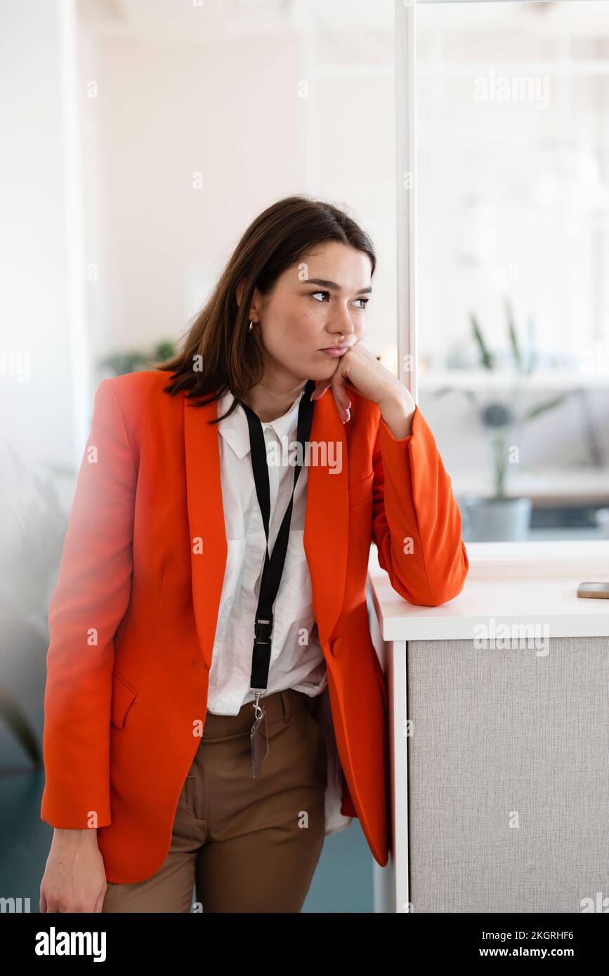Donna d'affari triste in piedi accanto al gabinetto in ufficio Foto Stock