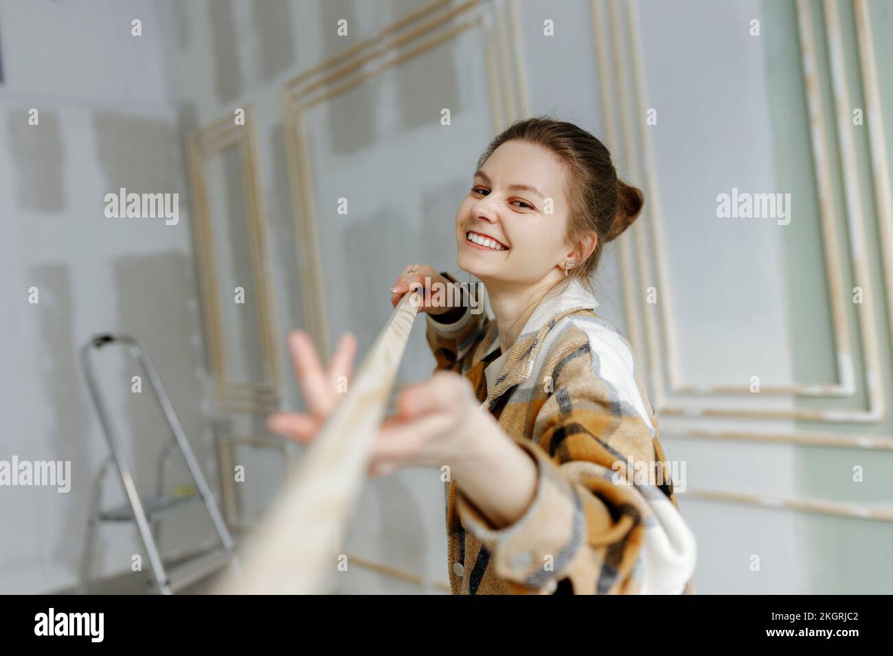 Donna sorridente con bastone di legno a casa Foto Stock
