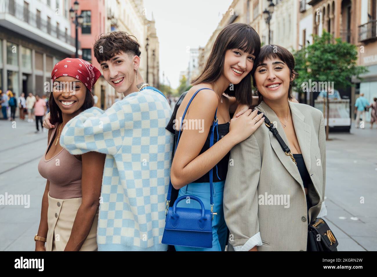 Felice giovane uomo con gli amici sulla strada Foto Stock