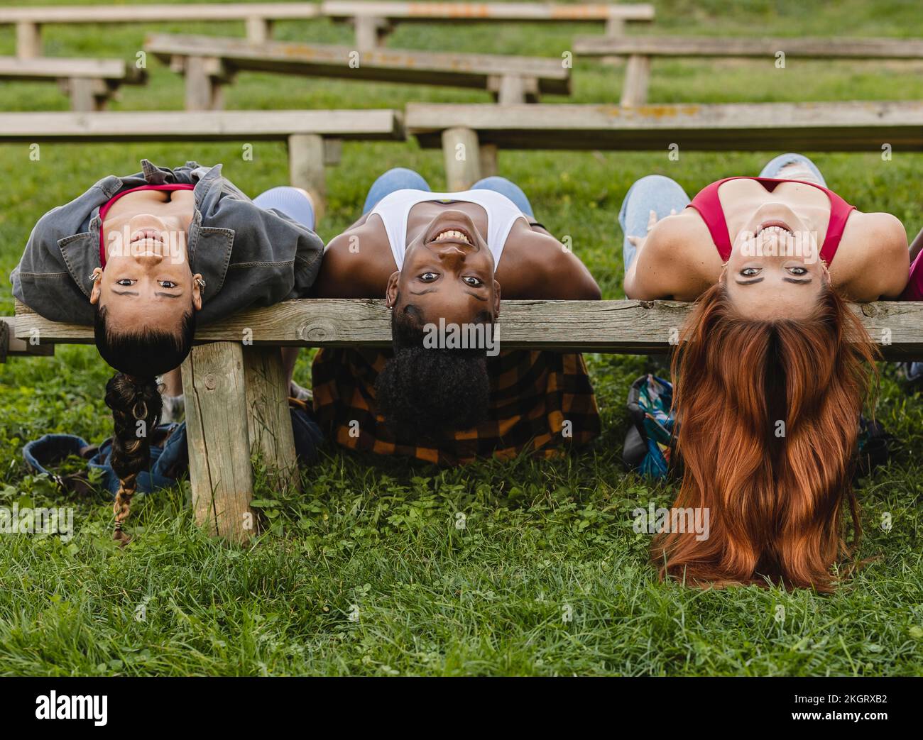 Giovani donne felici che riposano su una panchina nel parco Foto Stock