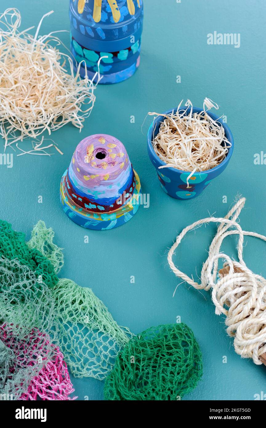 Rete, lana di legno e vasi colorati di terracotta dipinta Foto Stock