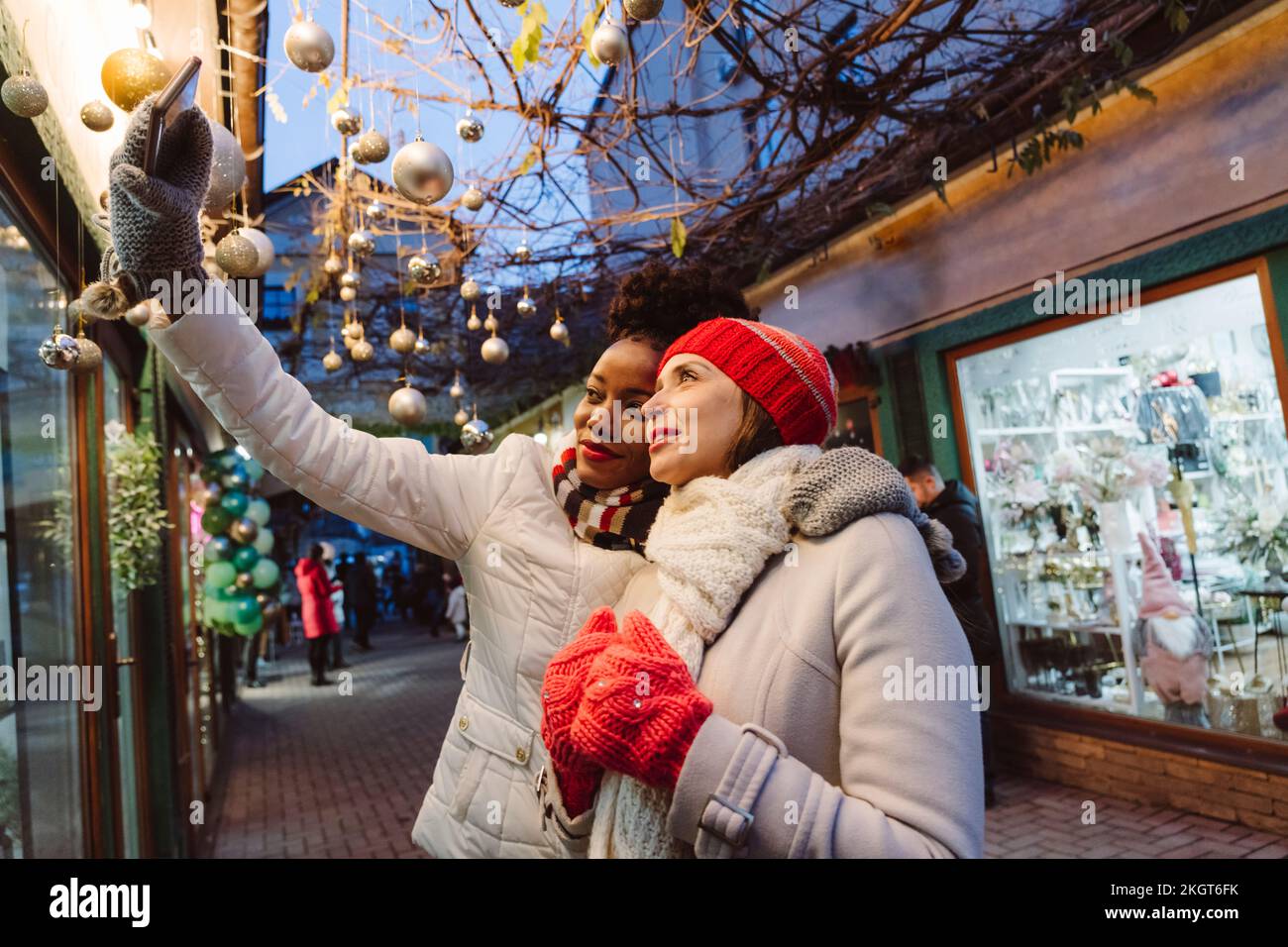 Amici che indossano abiti caldi che portano il selfie attraverso lo smartphone per strada Foto Stock
