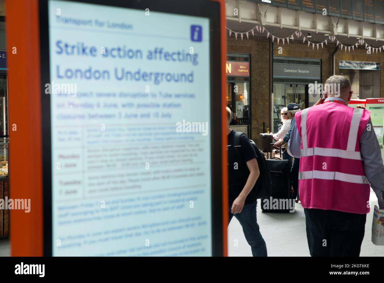 Il terzo giorno di sciopero ferroviario, i passeggeri passeranno davanti a una tavola elettrica che mostra un avviso dello sciopero ferroviario alla King’s Cross Station di Londra. Foto Stock