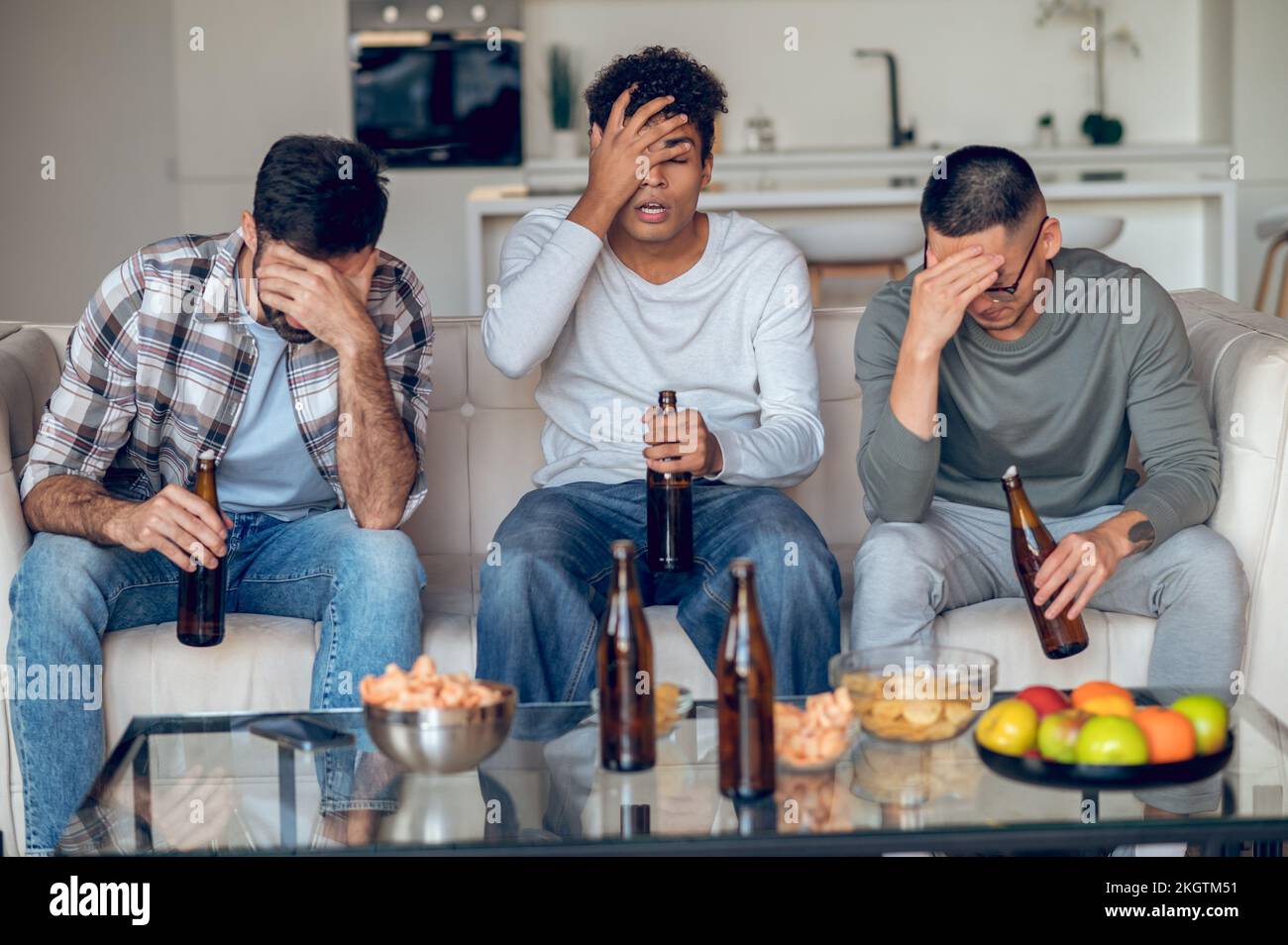 Tre giovani si sono arrabbiati seduti in camera Foto Stock