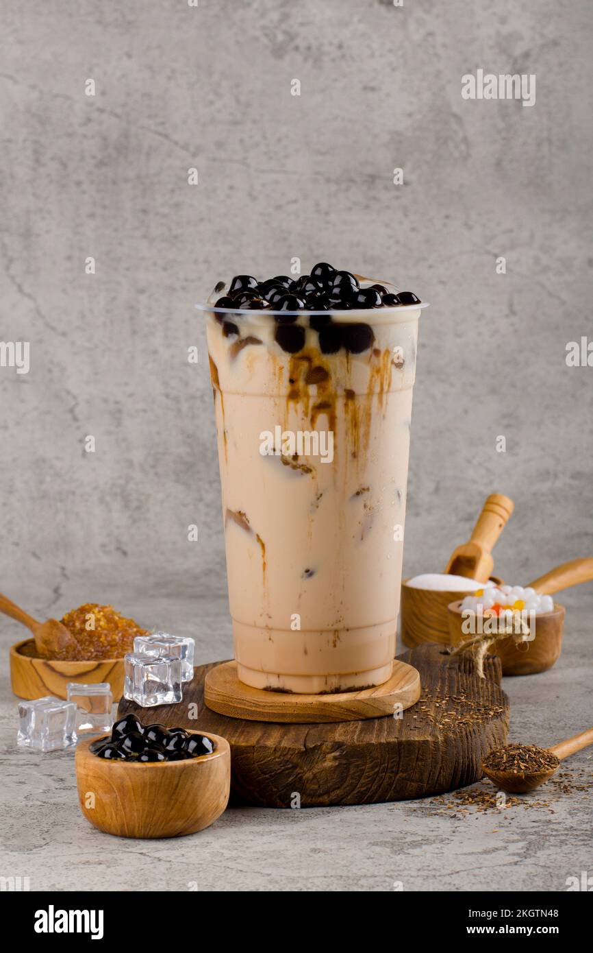 Le perle di Boba o tapioca sono tisana bolla latte tè in tazza di plastica con sapore di zucchero marrone su sfondo texture, estati ristoro. Foto Stock