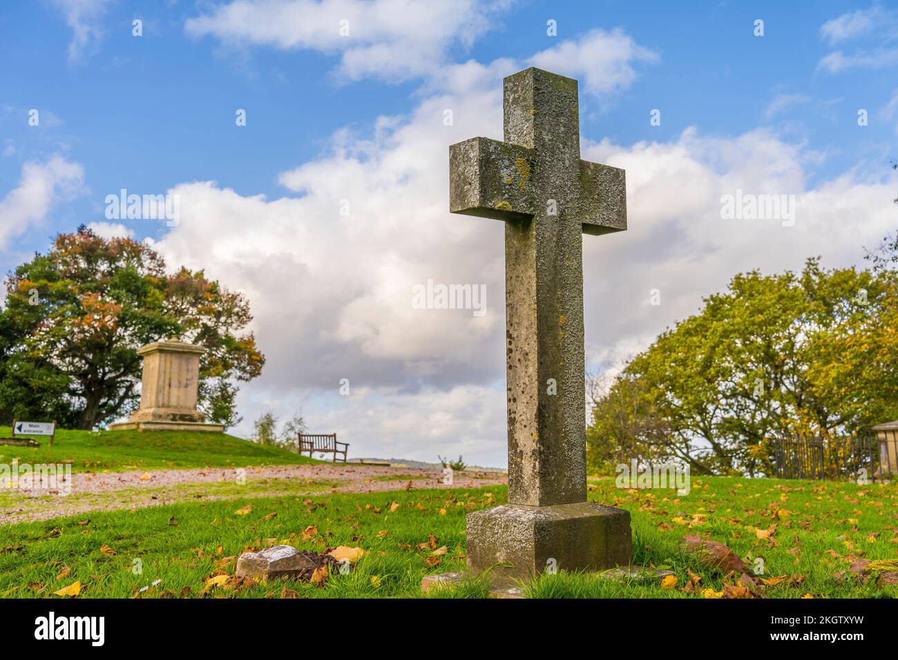 Croce di pietra / lapide commemorativa nel cimitero del Regno Unito all'aperto in autunno sole. Foto Stock