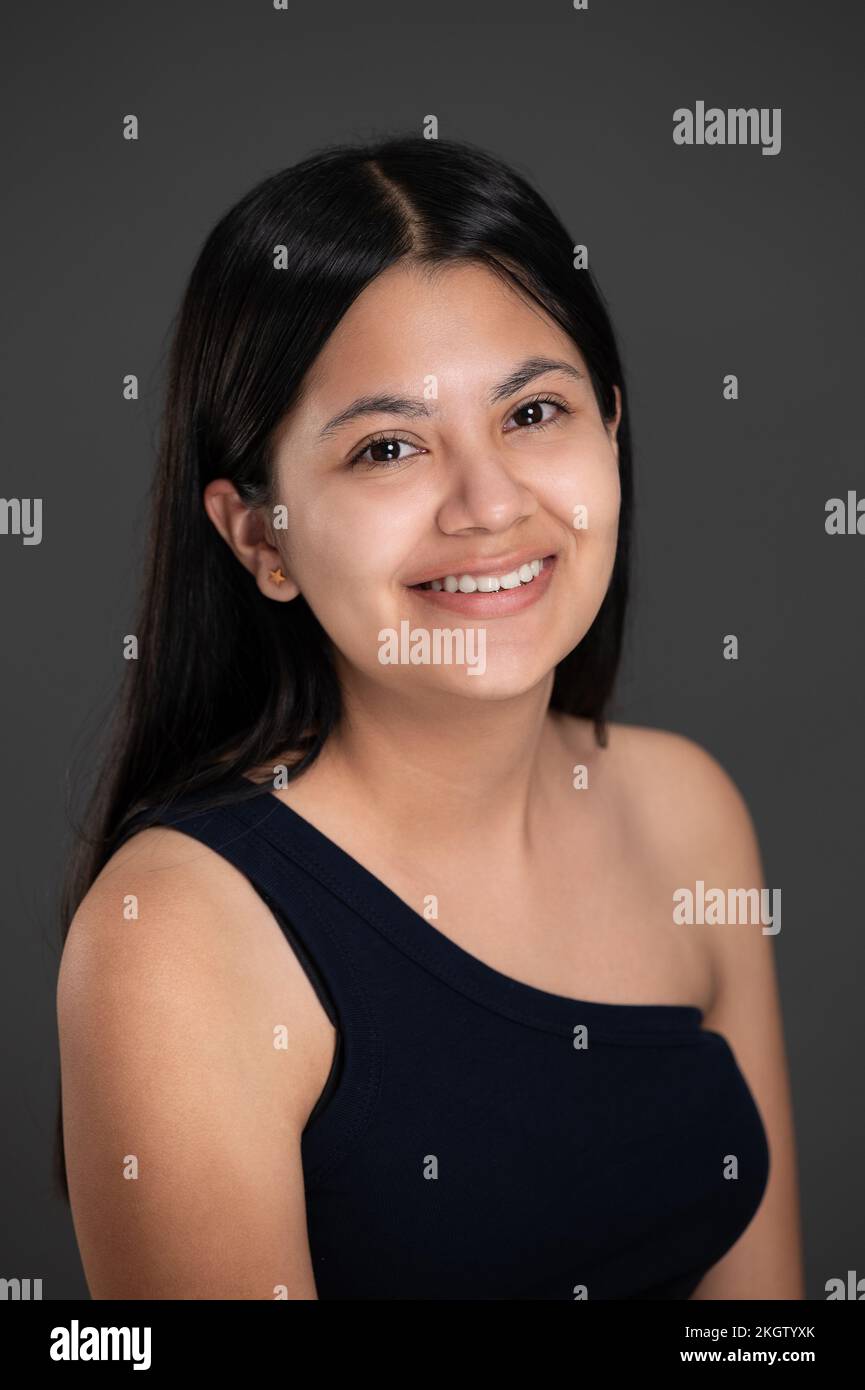 Ritratto di sorridente con denti ragazza latino su sfondo scuro studio Foto Stock