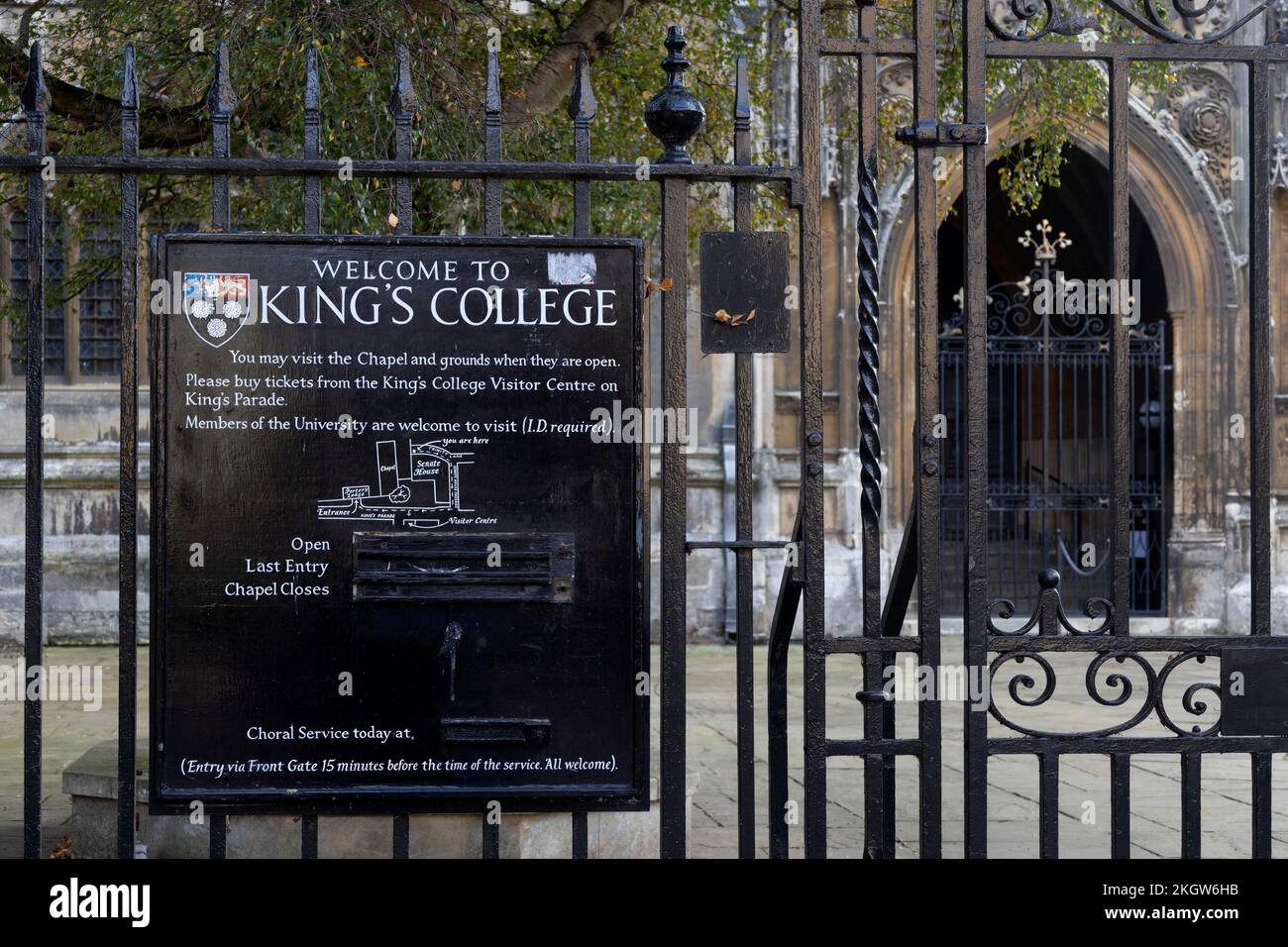 CAMBRIDGE, Regno Unito - 31 OTTOBRE 2022: Vista del Kings College attraverso ringhiere in ferro battuto con cartello Foto Stock