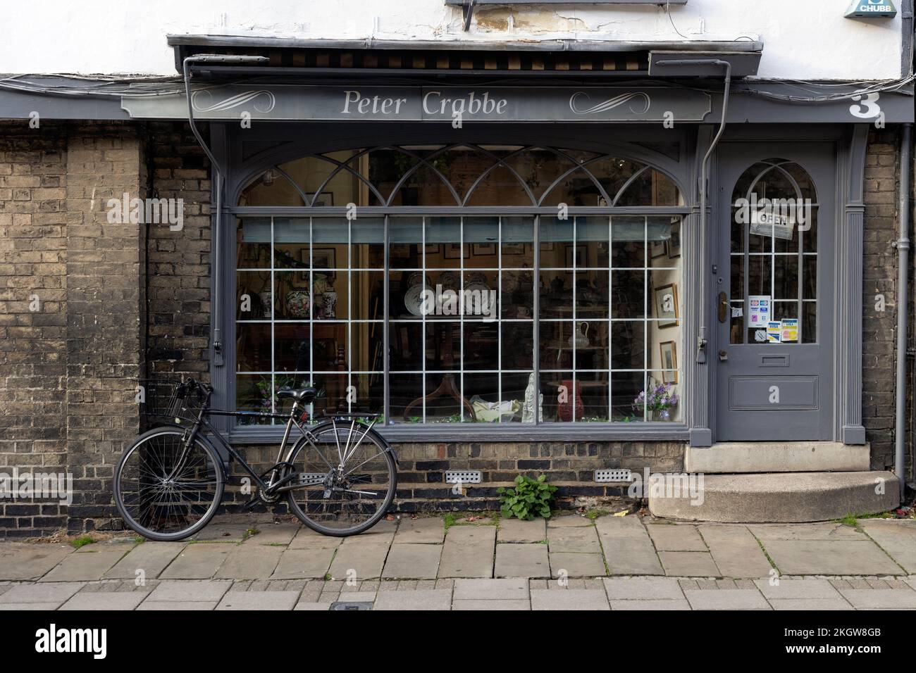 CAMBRIDGE, Regno Unito - 31 OTTOBRE 2022: Bicicletta al di fuori del negozio di antiquariato Peter Crabbe nel centro della città Foto Stock