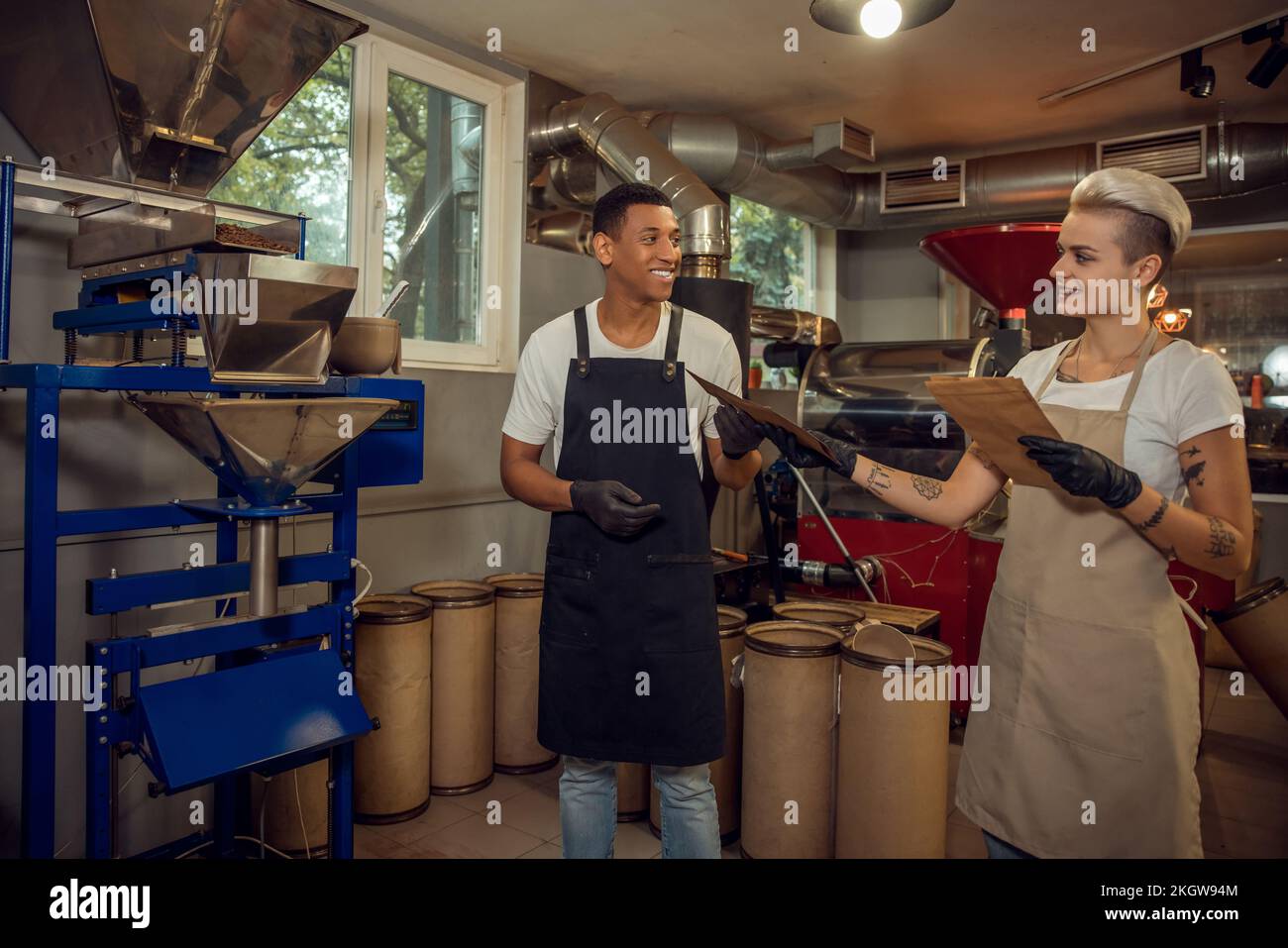 Due persone lavorano in una struttura di tostatura del caffè Foto Stock