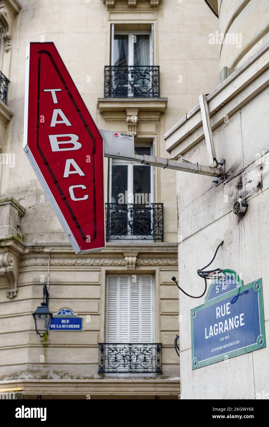 Cartello rosso Tabac in un angolo sulle strade di Parigi, Francia, con un tradizionale balcone cittadino francese dietro., cartello le Leggange Foto Stock