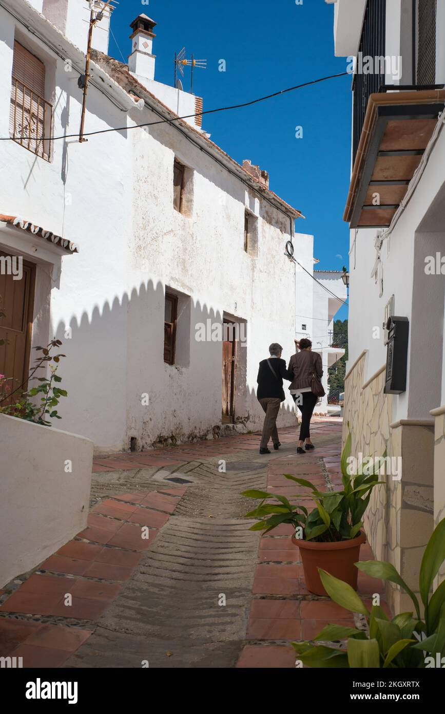 Due donne passeggiando per le strette strade di Ojén, Andalusia, Spagna, uno dei Pueblos Blancos sulla Costa del Sol. Foto Stock