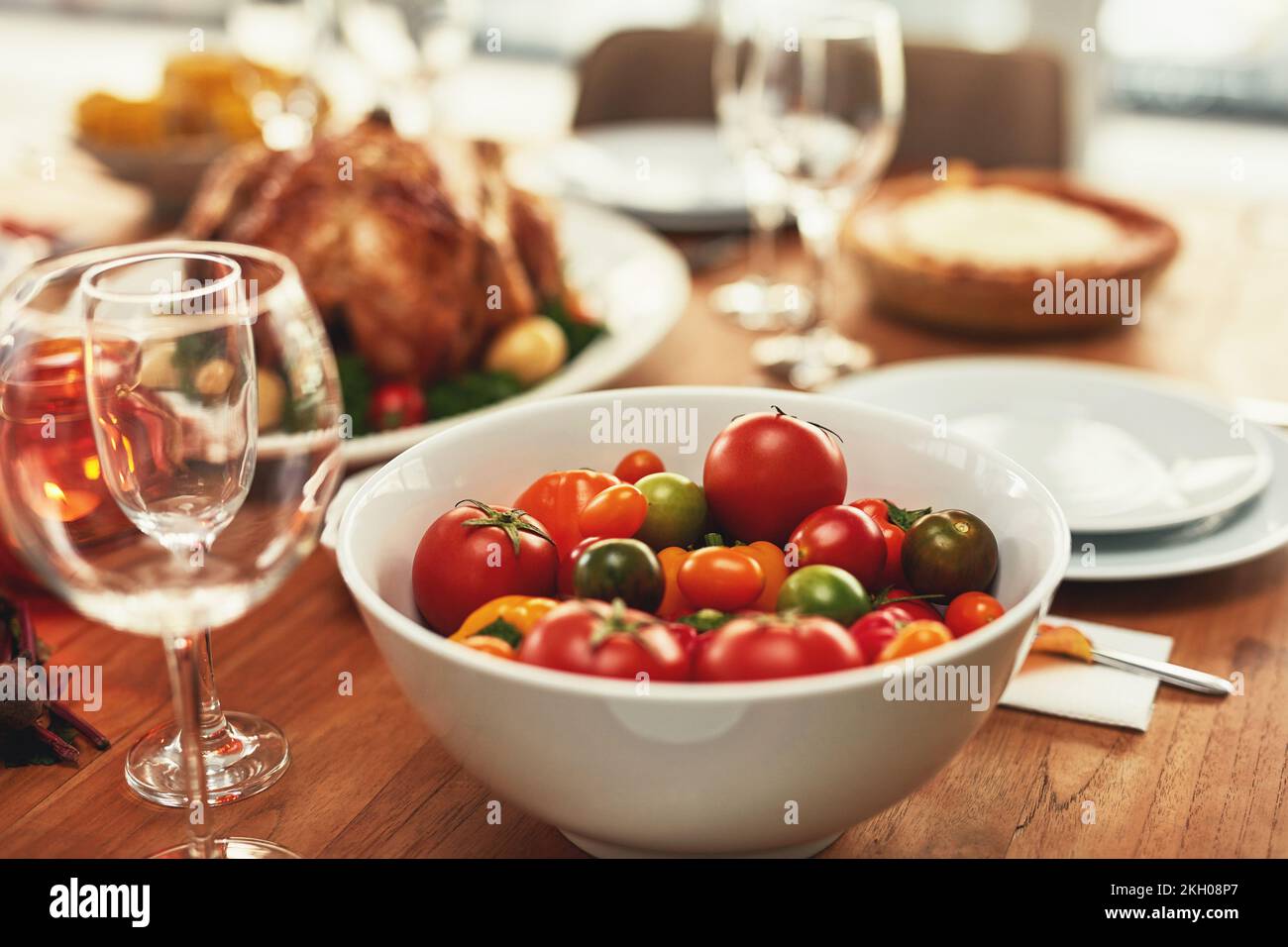 Cibo, tradizionale e festeggiamenti con pomodoro a tavola per il ringraziamento, pasto e lusso, tacchino e nessuno. Pollo, nutrizione e pranzo di famiglia impostazione Foto Stock