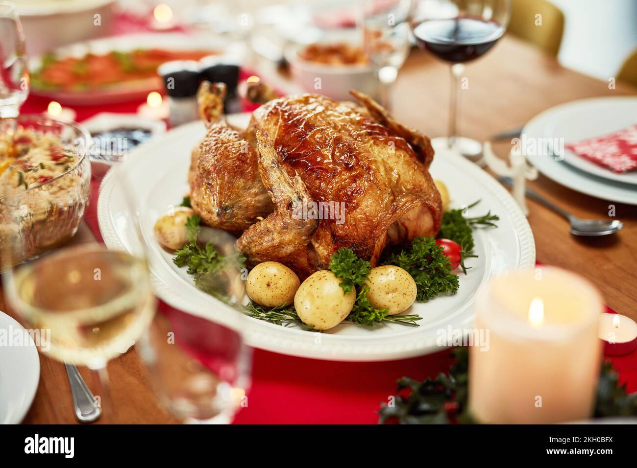 Ringraziamento, tacchino e cibo con un pasto su un tavolo da pranzo per la tradizione in una stanza vuota. Natale, pollo e cena di un posto impostazione per Foto Stock