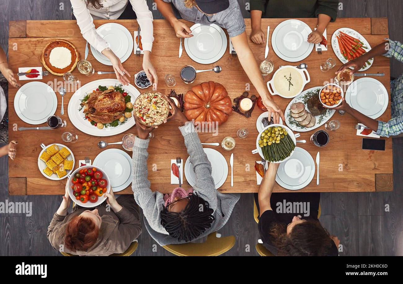 Vista dall'alto, cena di festa e tavolo di ringraziamento in casa sociale, casa o ristorante con cibo festivo. Sopra, sala da pranzo o gruppo di amici con Foto Stock