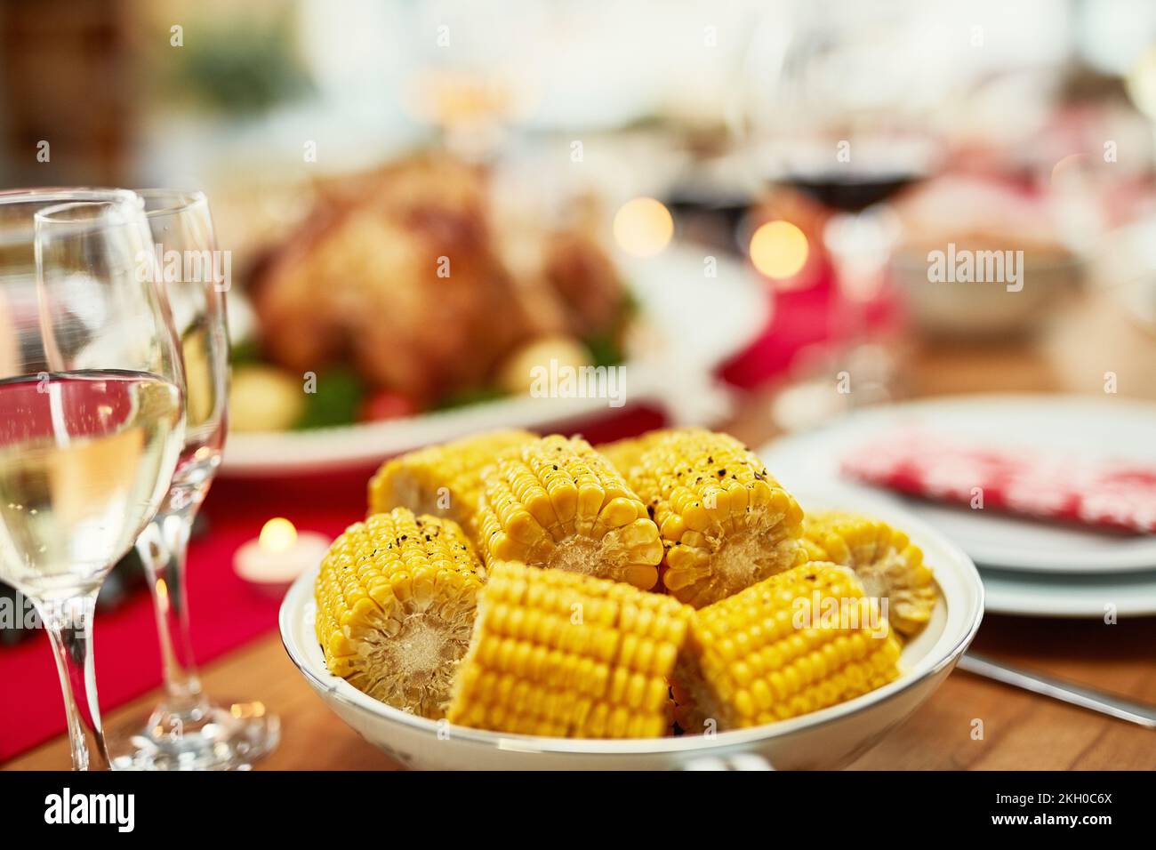 Mais, sano e pranzo su un tavolo per una celebrazione, Natale e nutrizione in una casa. Cibo, vacanze e cena nella sala da pranzo per festeggiare Foto Stock