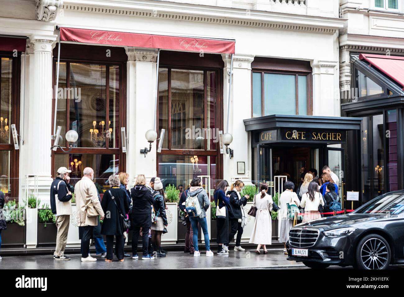 Vienna, Austria - 14 ottobre 2022: Fila di persone in attesa di fronte al Cafe Sacher, un edificio classico a Innere Stadt, Vienna, Austria Foto Stock