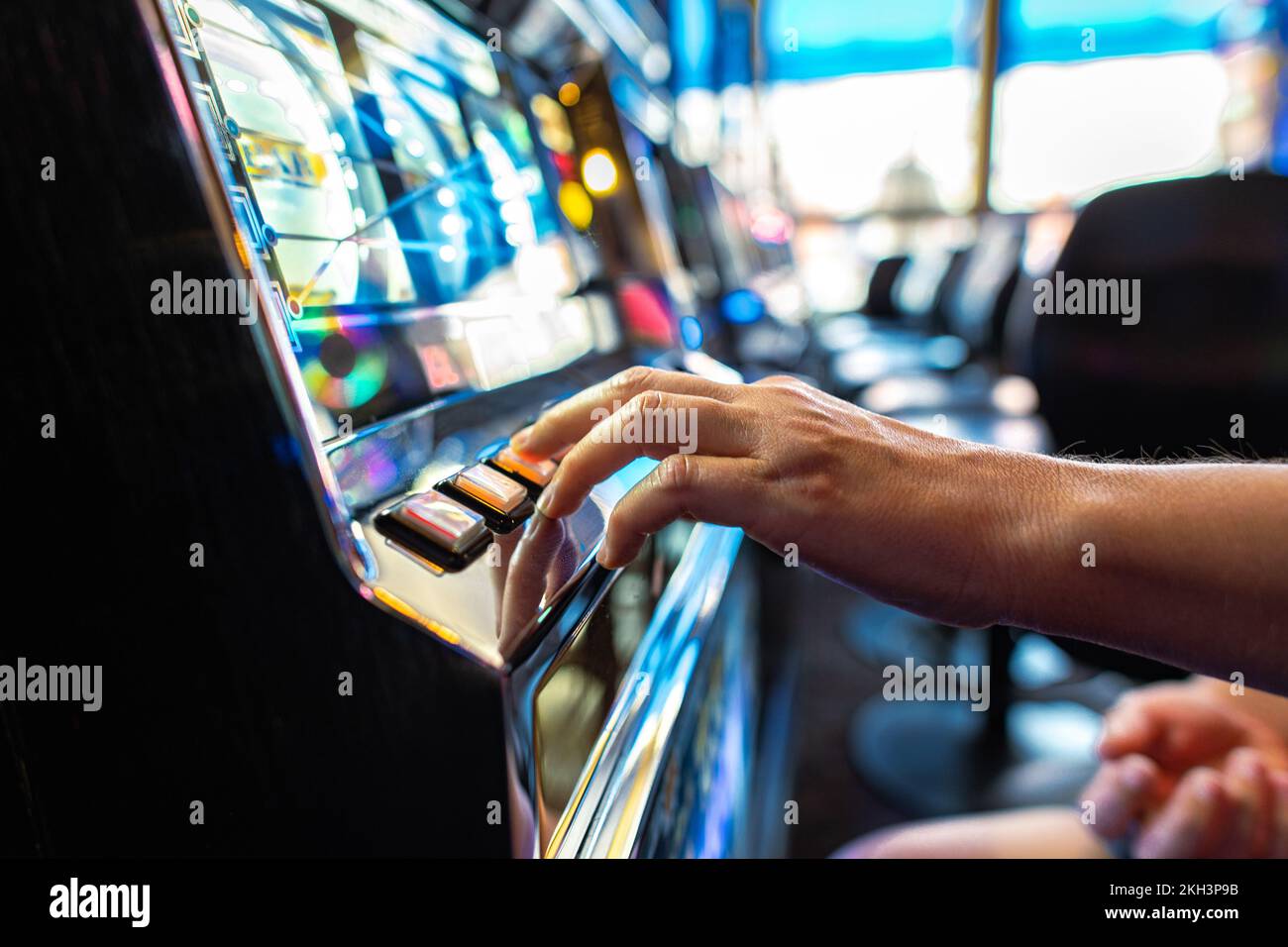 Primo piano del giocatore premendo il pulsante Spin mentre si gioca slot Machine nel Casinò. Tema dell'industria del gioco d'azzardo. Foto Stock