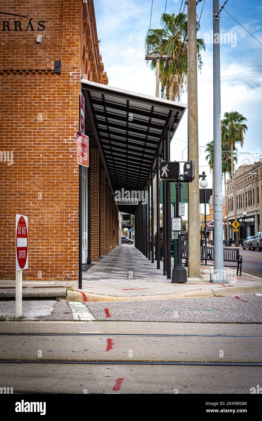 Un'immagine verticale di un marciapiede accanto a un vecchio edificio in mattoni e un poster che mostra l'entrata della Trucker Hall, Florida Foto Stock