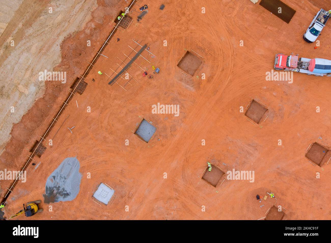 In un cantiere di grandi dimensioni, vengono preparati trincee per il travaso di calcestruzzo nelle fondazioni come parte di un progetto di costruzione più ampio Foto Stock