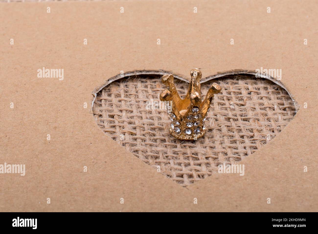 Crown visto attraverso la forma di cuore tagliato fuori di cartone Foto Stock