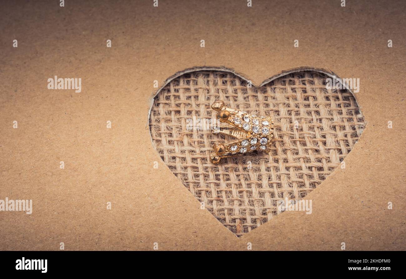 Crown visto attraverso la forma di cuore tagliato fuori di cartone Foto Stock