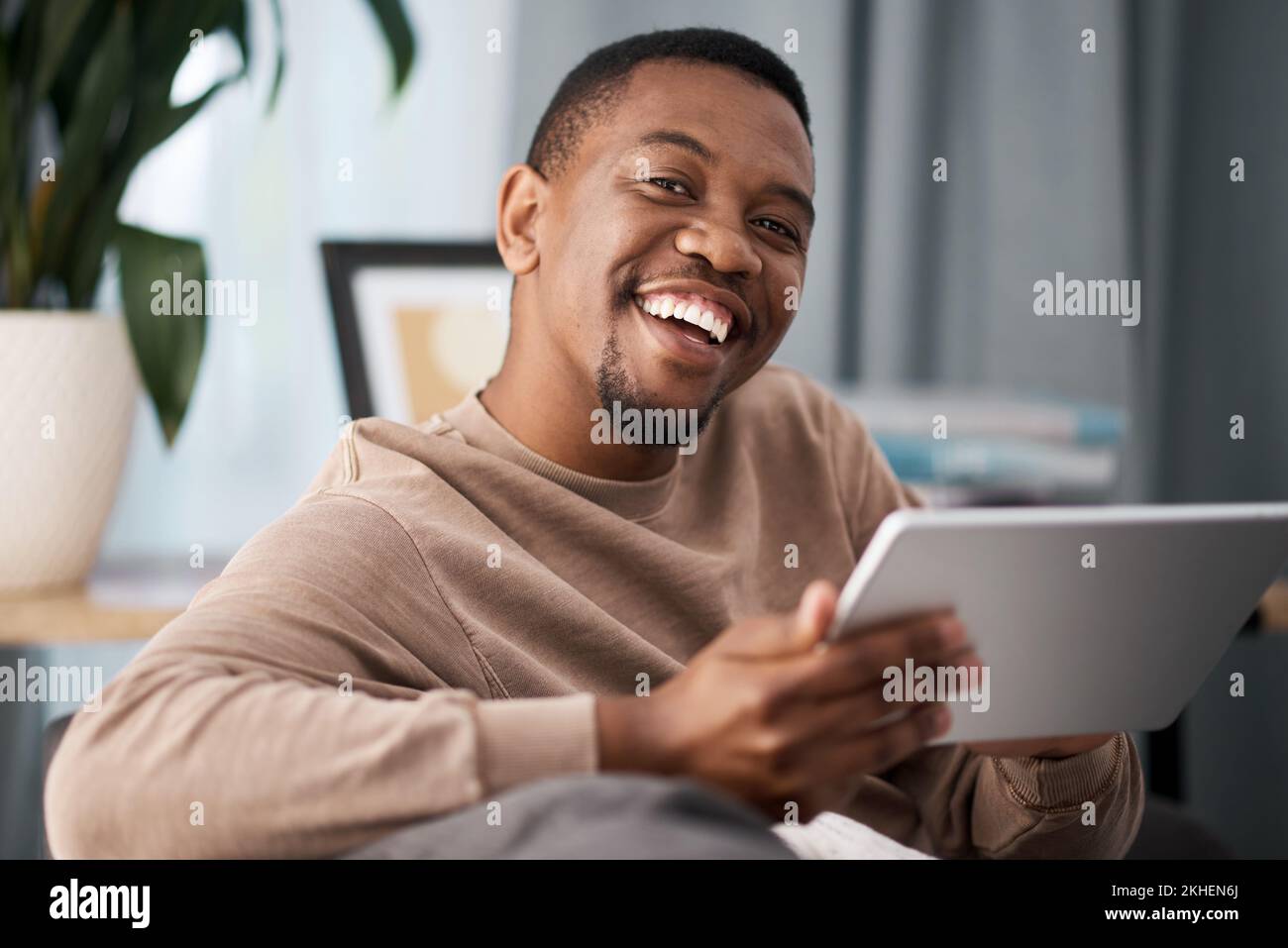 Uomo nero, tablet e ritratto sorridente per l'intrattenimento, lo streaming di film o la connessione ad alta velocità a casa. Felice maschio afro-americano sorridente dentro Foto Stock