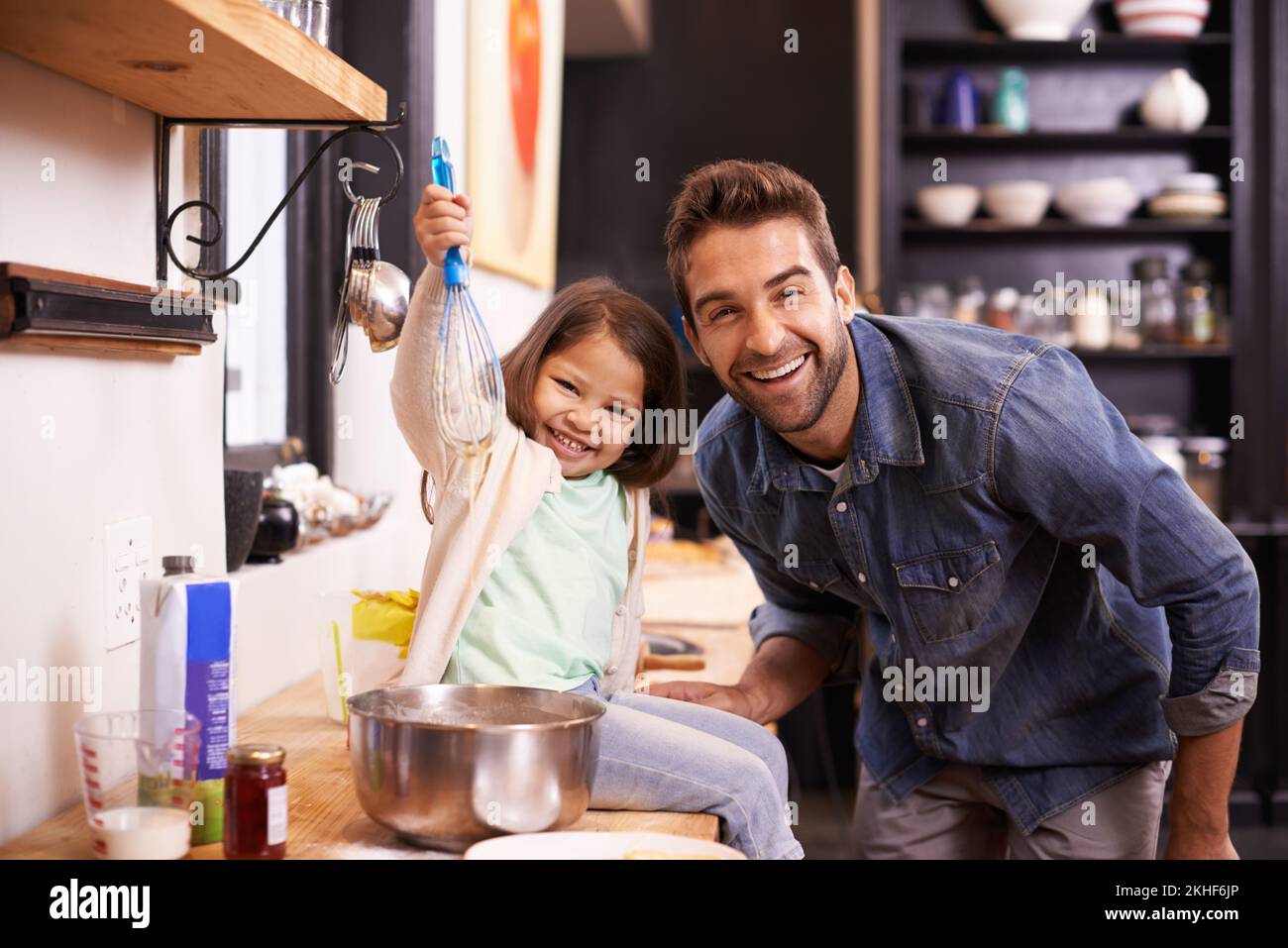 Le ceneri daddys piccolo aiuto. Una bambina carina che aiuta il papà a fare frittelle a casa. Foto Stock