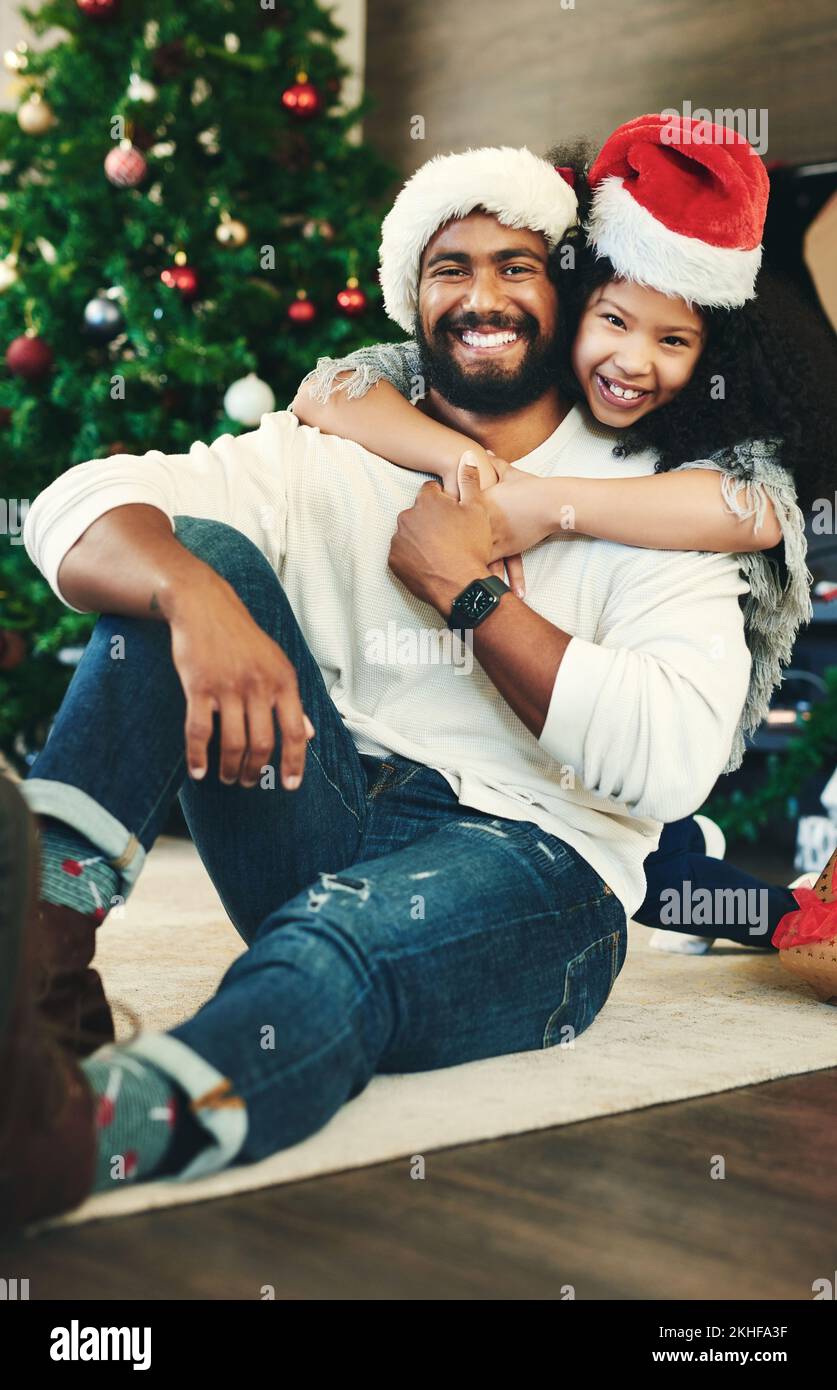 Padre, ritratto del bambino, abbraccio e festa di Natale, insieme e felice con il sorriso a casa. Albero di Natale, decorazione e festivo, messicano Foto Stock