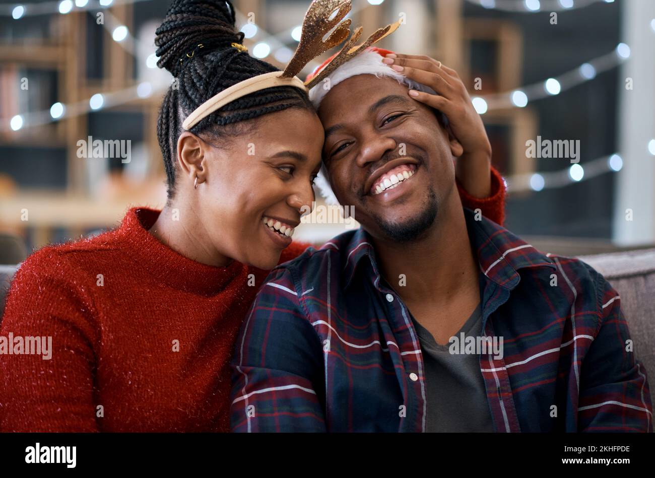 Felice coppia nera, divano e natale nel salotto di casa insieme, seduta e celebrazione. Donna nera, uomo e sorriso con felicità di vacanza, casa Foto Stock