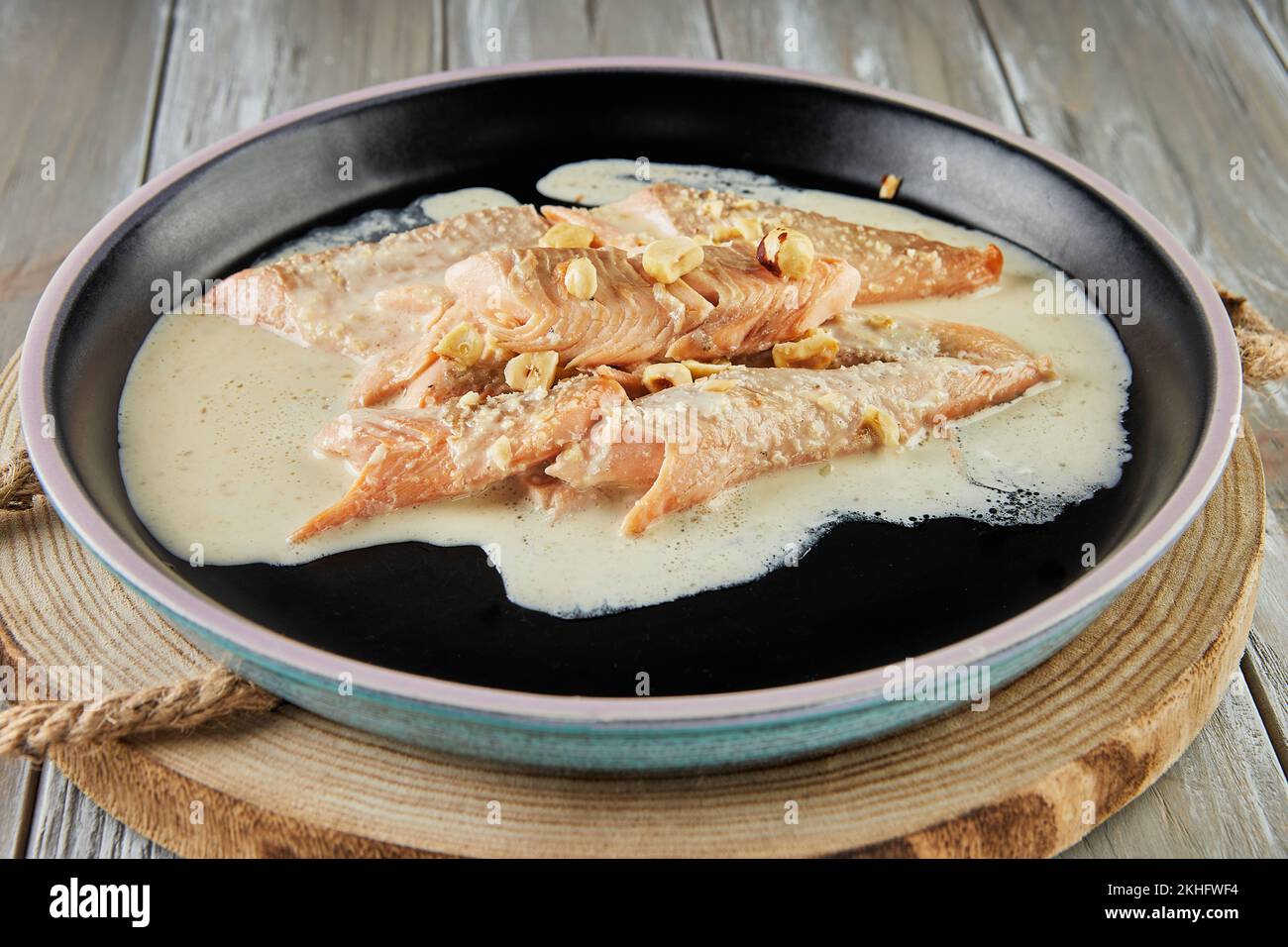Pesce trota con nocciole e salsa di panna cotta al forno. Cucina francese gourmet. Foto Stock
