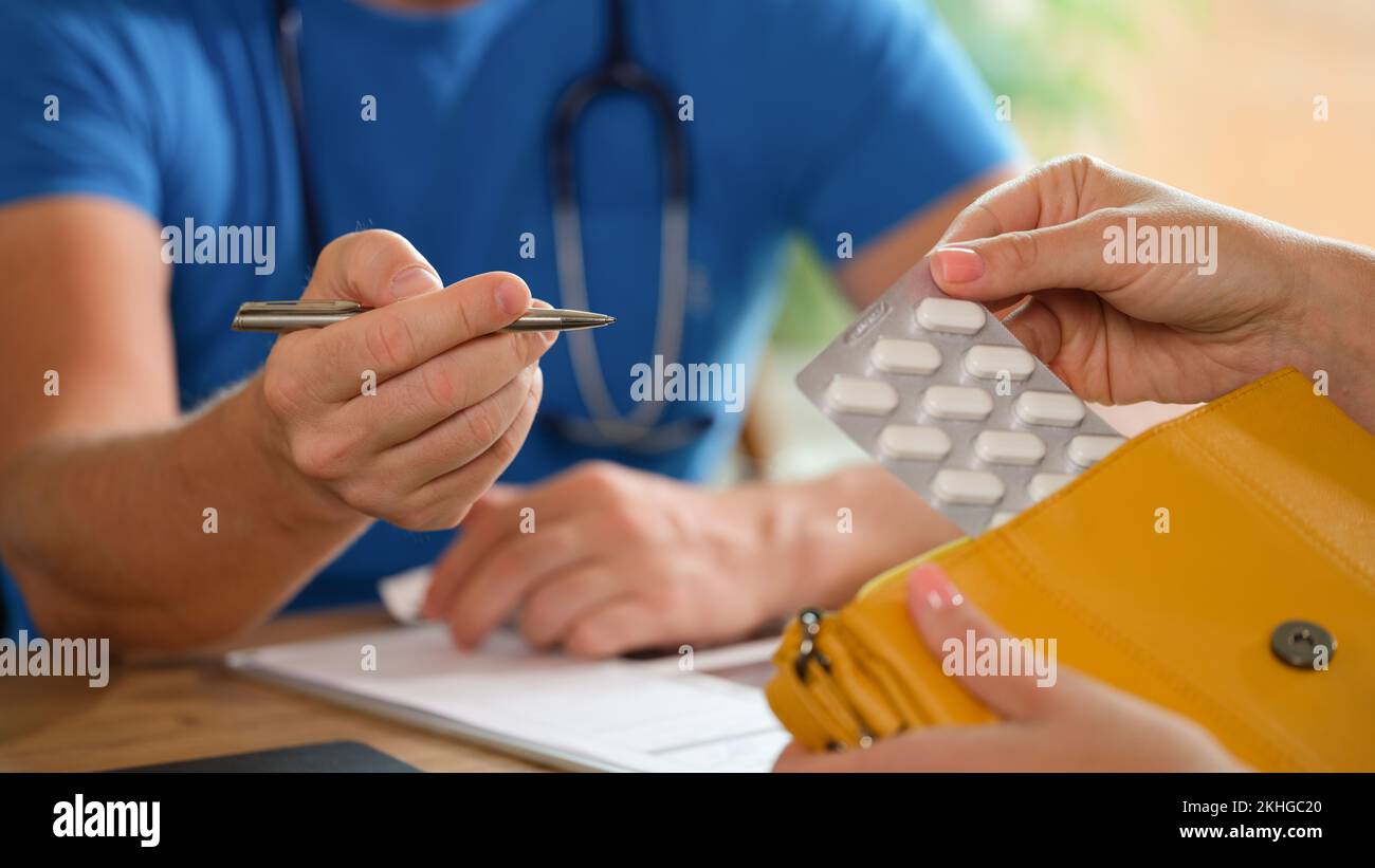 Uomo medico che consulta paziente femmina circa le pillole Foto Stock