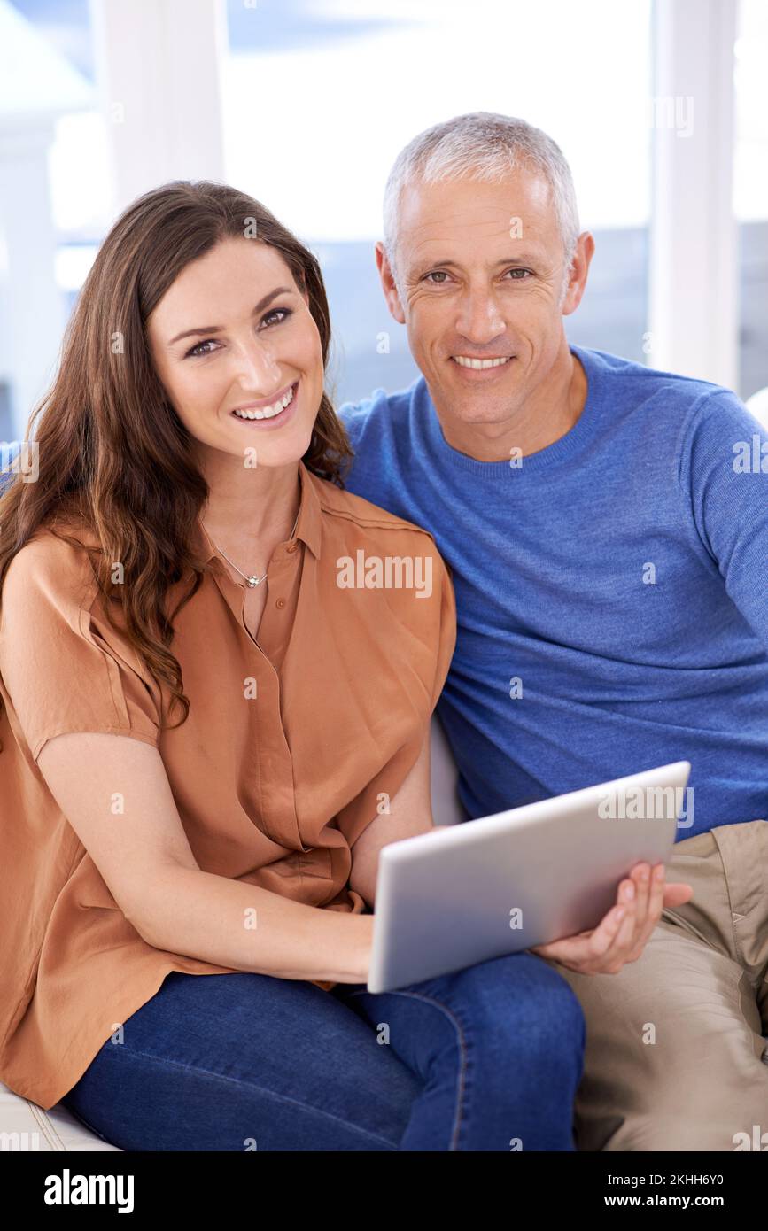 Condividere il nostro tempo online. una coppia felice a casa utilizzando il tablet digitale insieme. Foto Stock