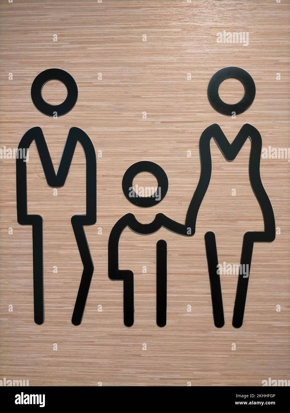 Una parete verticale in acrilico di una silhouette di famiglia su uno sfondo di legno Foto Stock