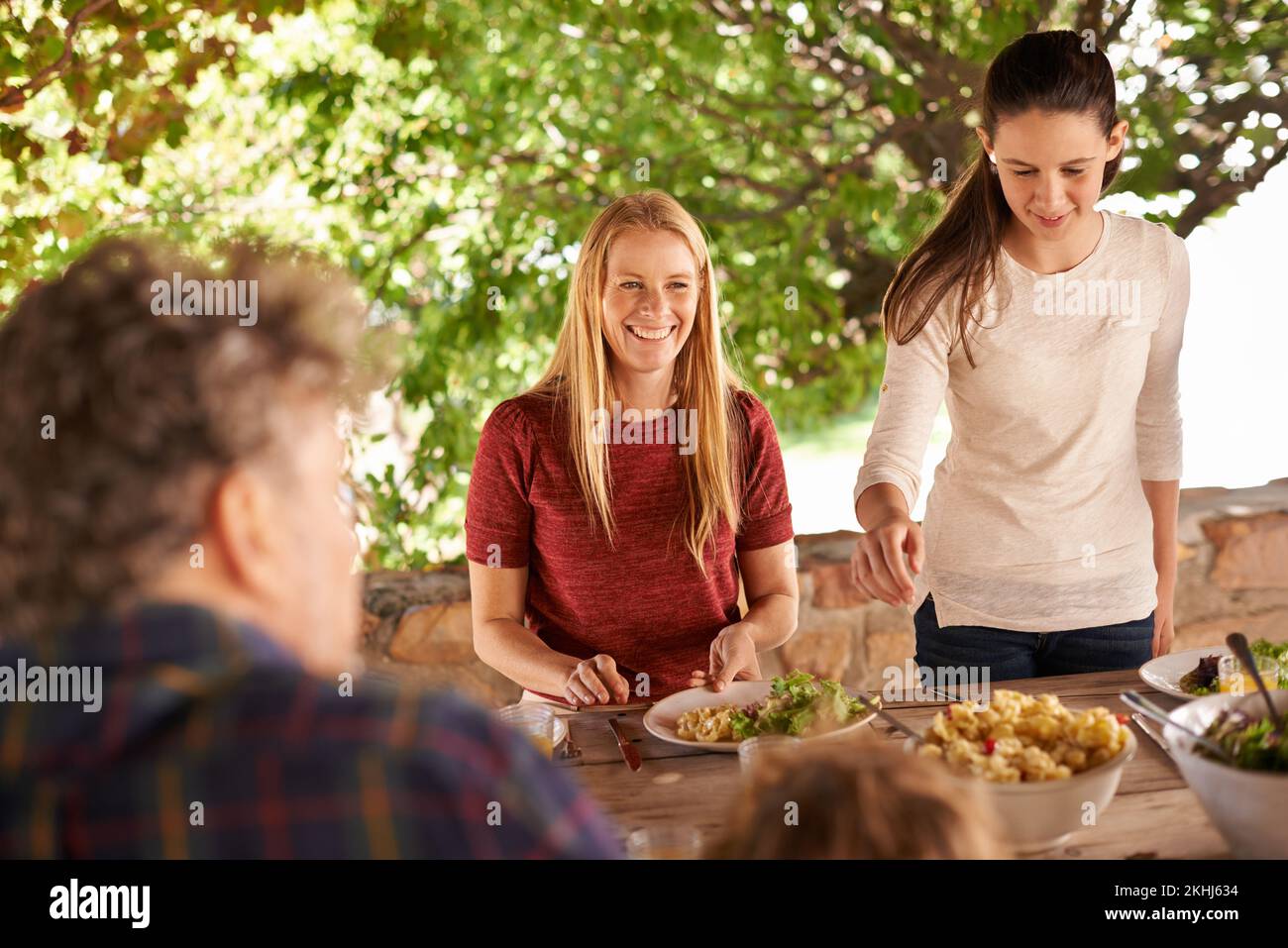 I pasti in famiglia sono i migliori. Una vista di una famiglia che si prepara a pranzare insieme all'aperto. Foto Stock