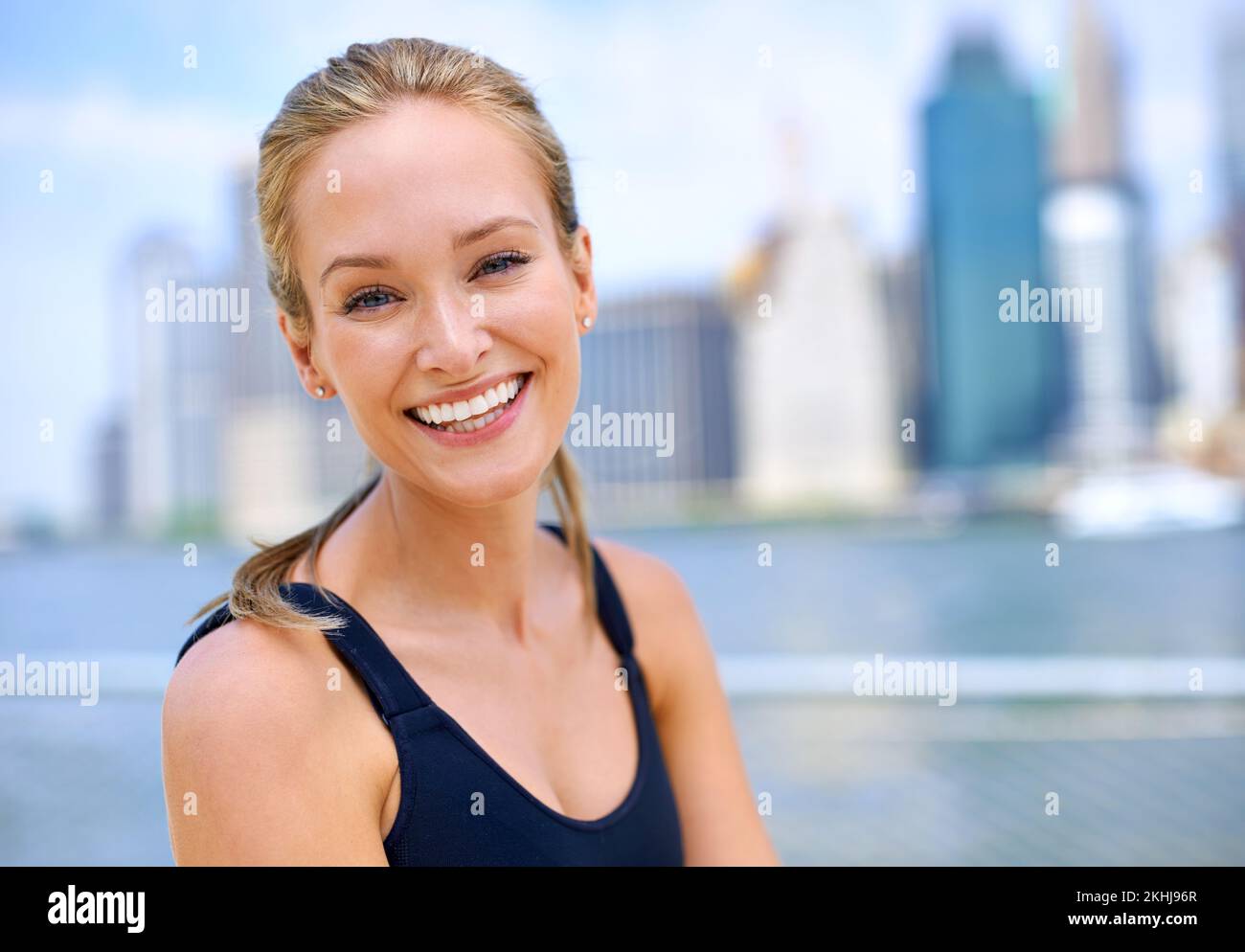 Shes un abitatore di città fit. Ritratto di una bella giovane donna in piedi accanto ad un fiume mentre fuori per una corsa in città. Foto Stock