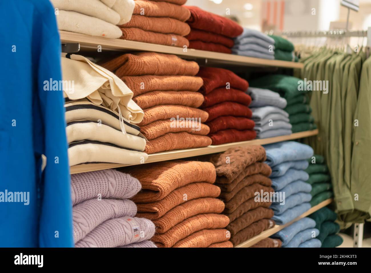 Primo piano degli scaffali con pullover colorati nel centro commerciale. Concetto di shopping, isolamento per l'autunno e l'inverno Foto Stock