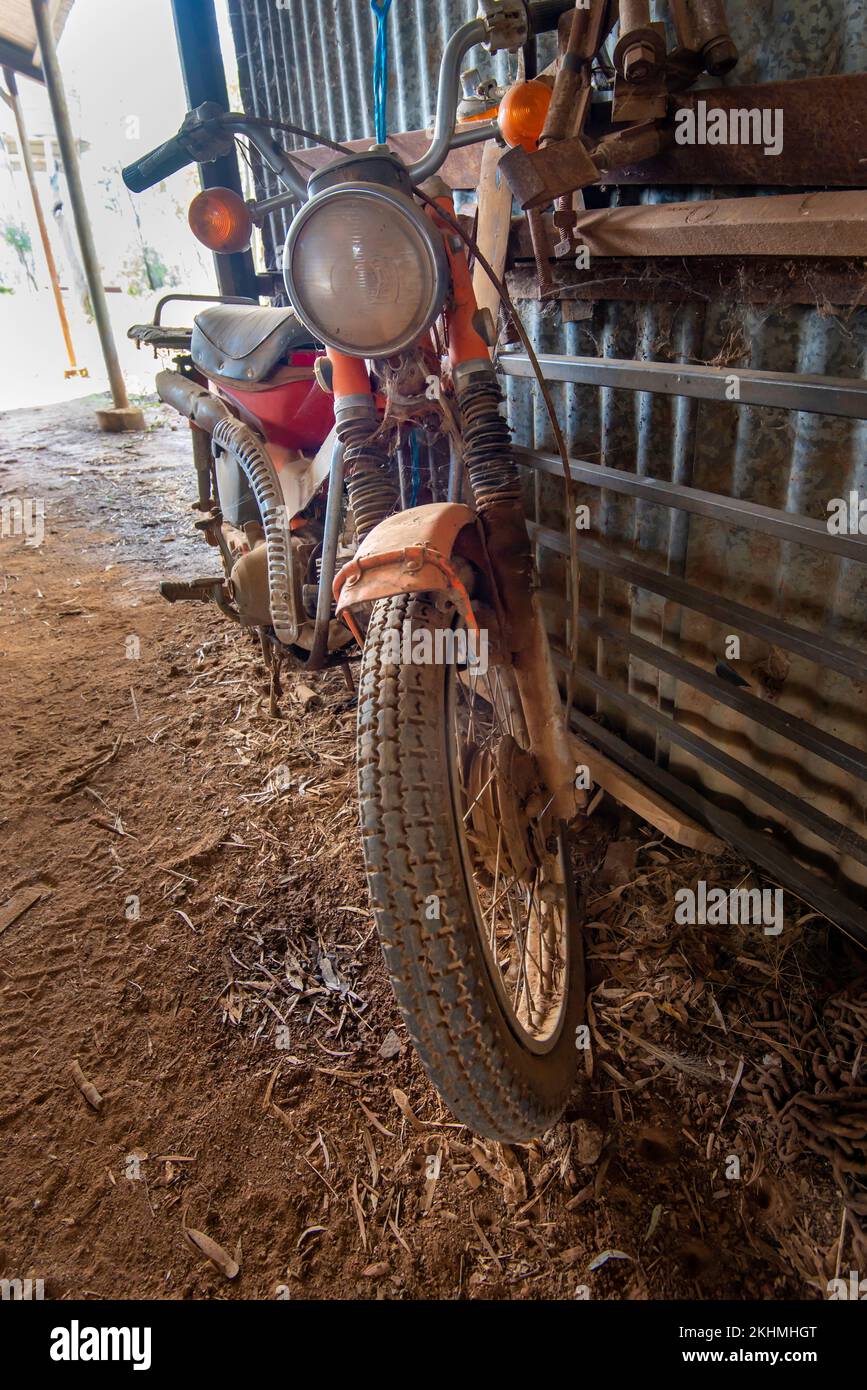 Una Honda CT90 che raccoglie polvere in un capannone nel nord-ovest del New South Wales, Australia. Una piccola moto passo-attraverso Honda tra il 1966 e il 1979 Foto Stock