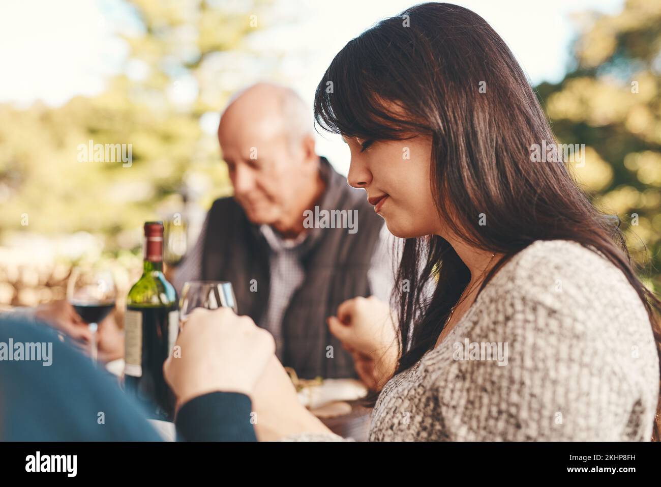 Persone, la preghiera prima di mangiare cibo per il legame, il contenuto per il pranzo e all'aperto. Gesto religioso, gruppo e mani in mano per il brunch, riunione di famiglia Foto Stock