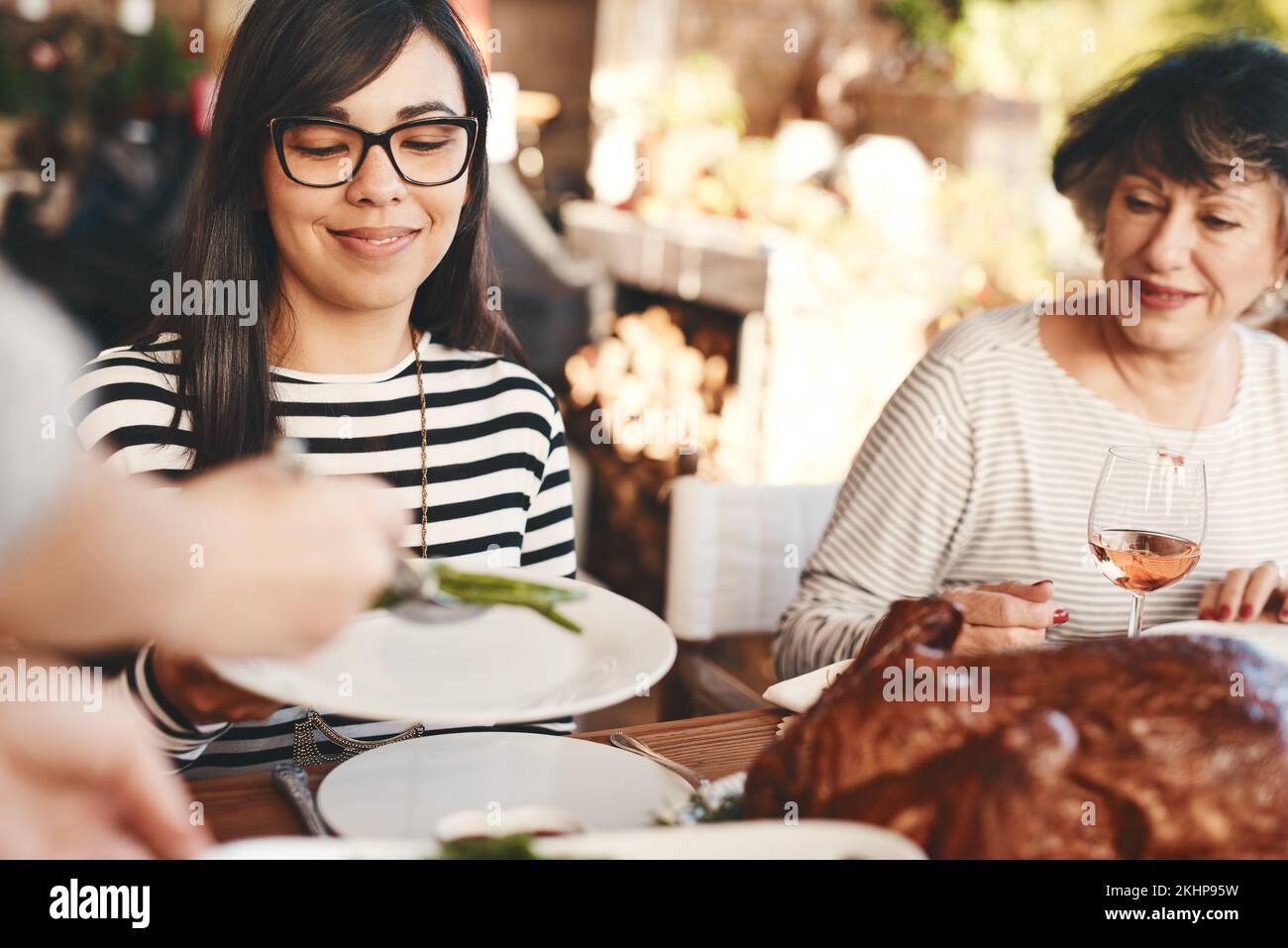 Cibo, vino e festeggiare con cena, festa con le donne e pasto per le feste all'aperto. Festa di Natale o di ringraziamento con la famiglia, sociale Foto Stock