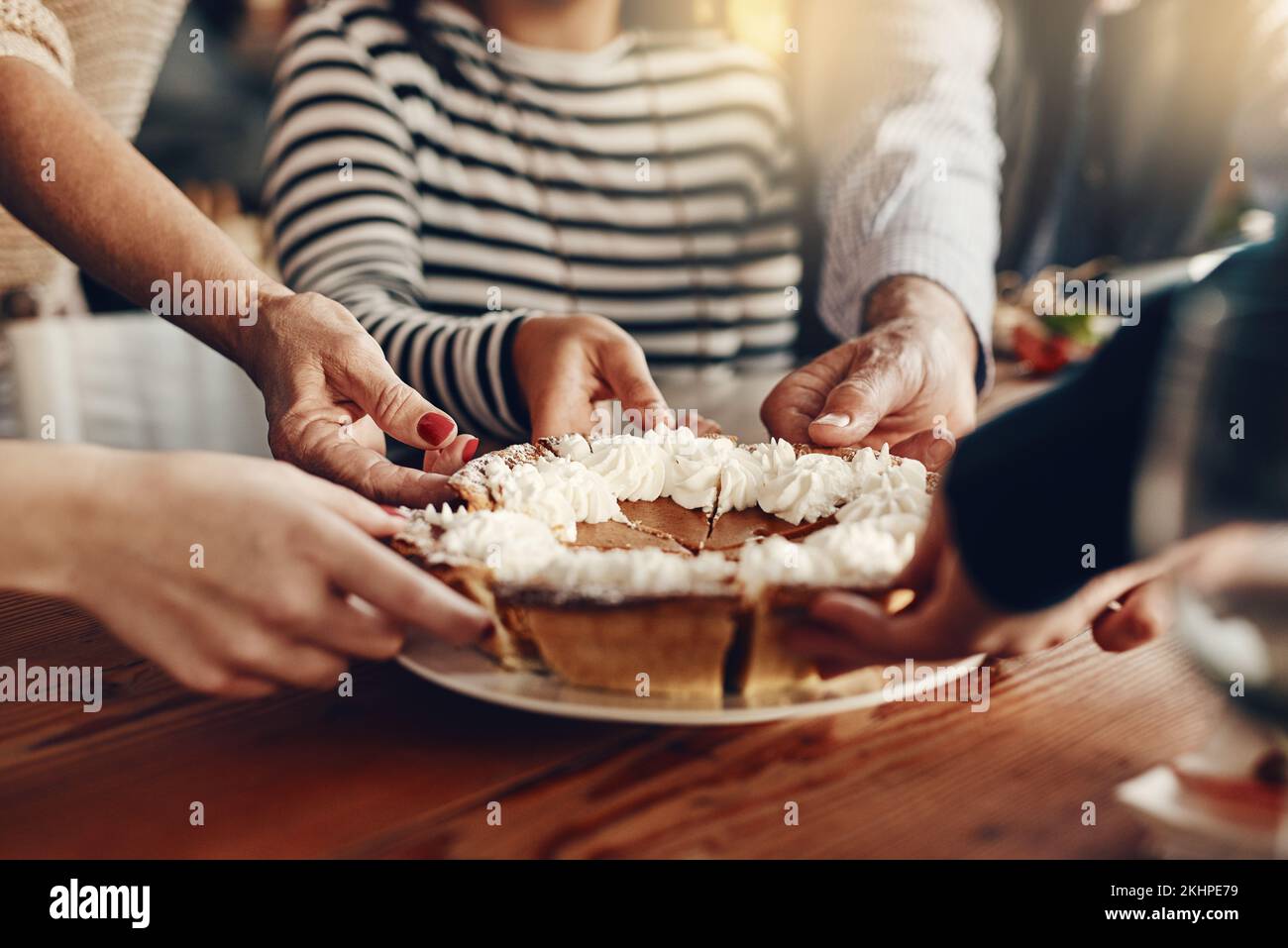 Persone, mani e torta di zucca a una festa per una celebrazione di ringraziamento, evento o riunione a casa. Dessert tradizionale, torta o torta in vacanza Foto Stock
