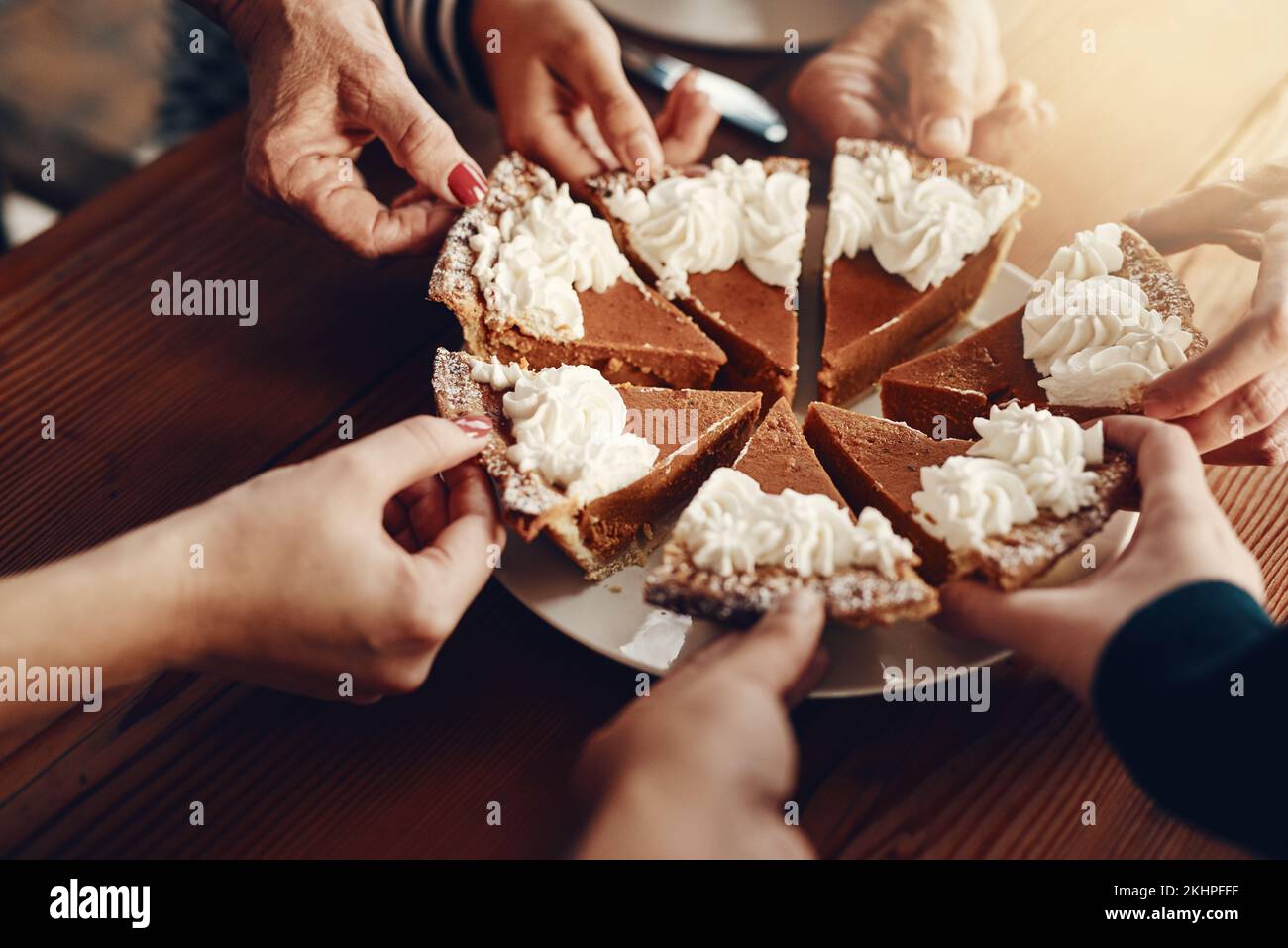 Torta, celebrazione e mani di famiglia ad una festa per il pranzo di Natale insieme in una casa. Cibo, condivisione e amici con la torta per dessert dopo Foto Stock